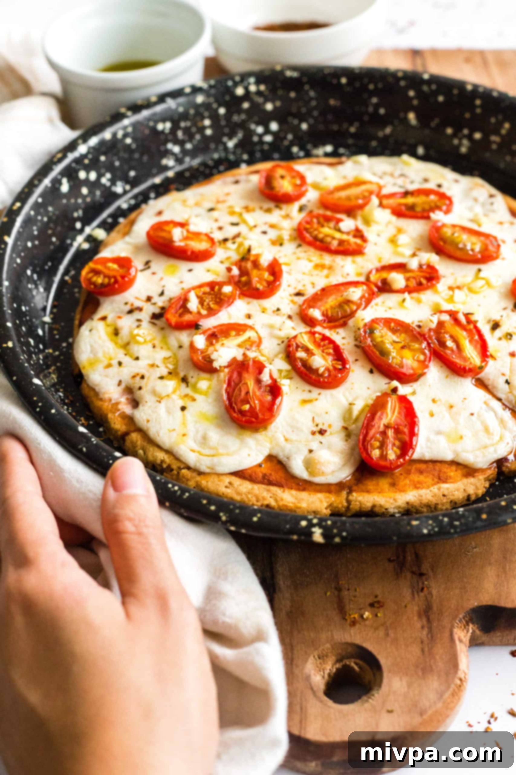 Gluten-free pizza in a pizza pan on a wooden board