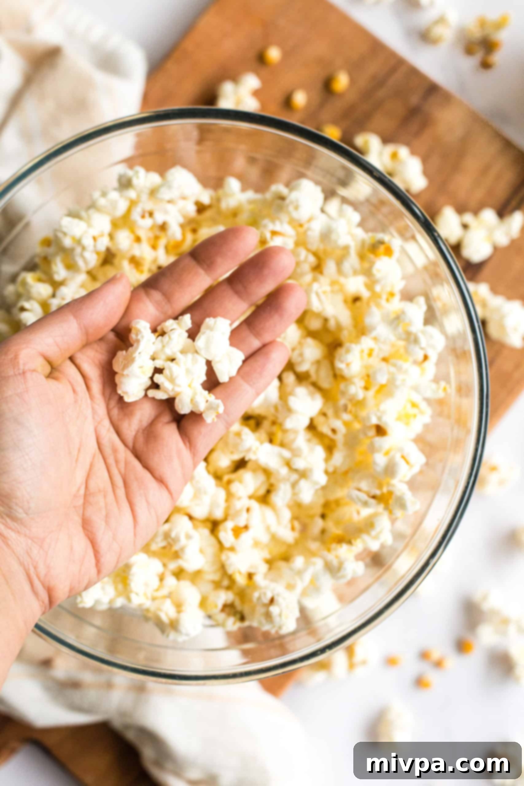Easy Stovetop Popcorn (with Microwave option) Hand holding freshly made popcorn