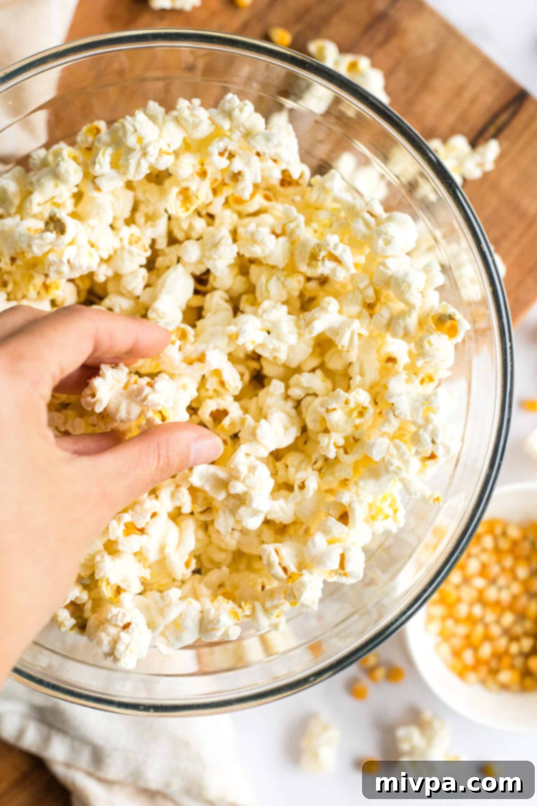 Easy Stovetop Popcorn (with Microwave option) Freshly popped popcorn in a glass bowl.