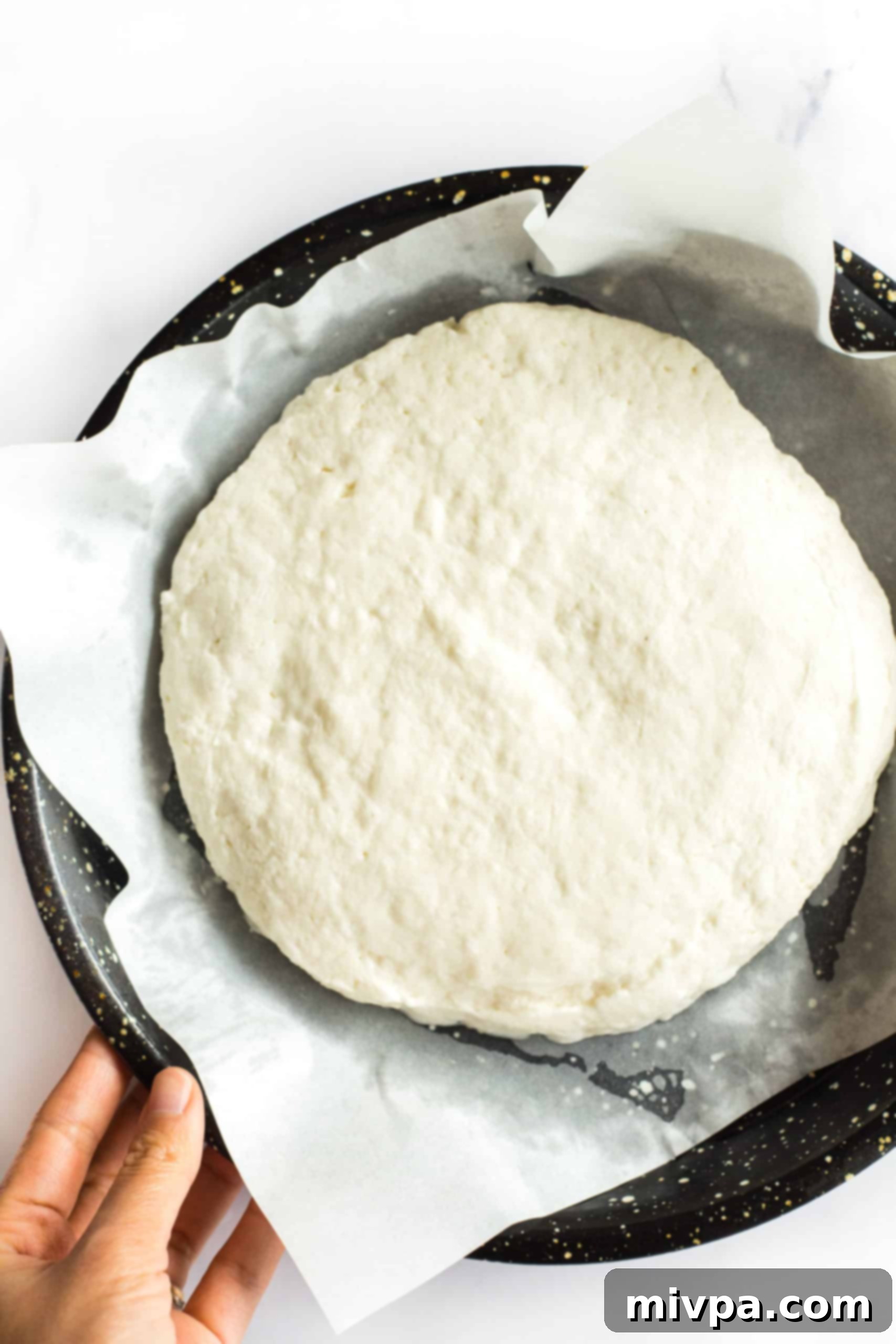 Gluten-Free Focaccia Bread Recipe (Dairy-Free, Vegan) Gluten-free focaccia bread dough after rising in a parchment-lined baking sheet.