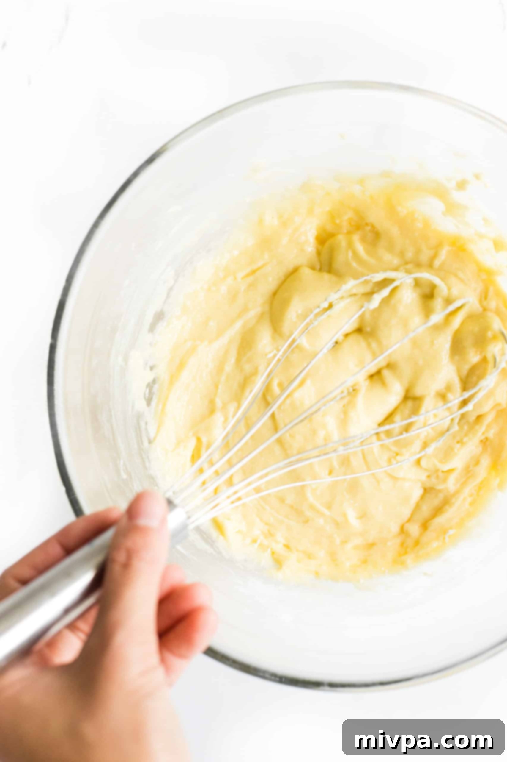 Fluffy Gluten-Free Pancakes (Dairy-Free) Gluten-free pancake batter being gently whisked in a bowl, showcasing its thick yet smooth texture.