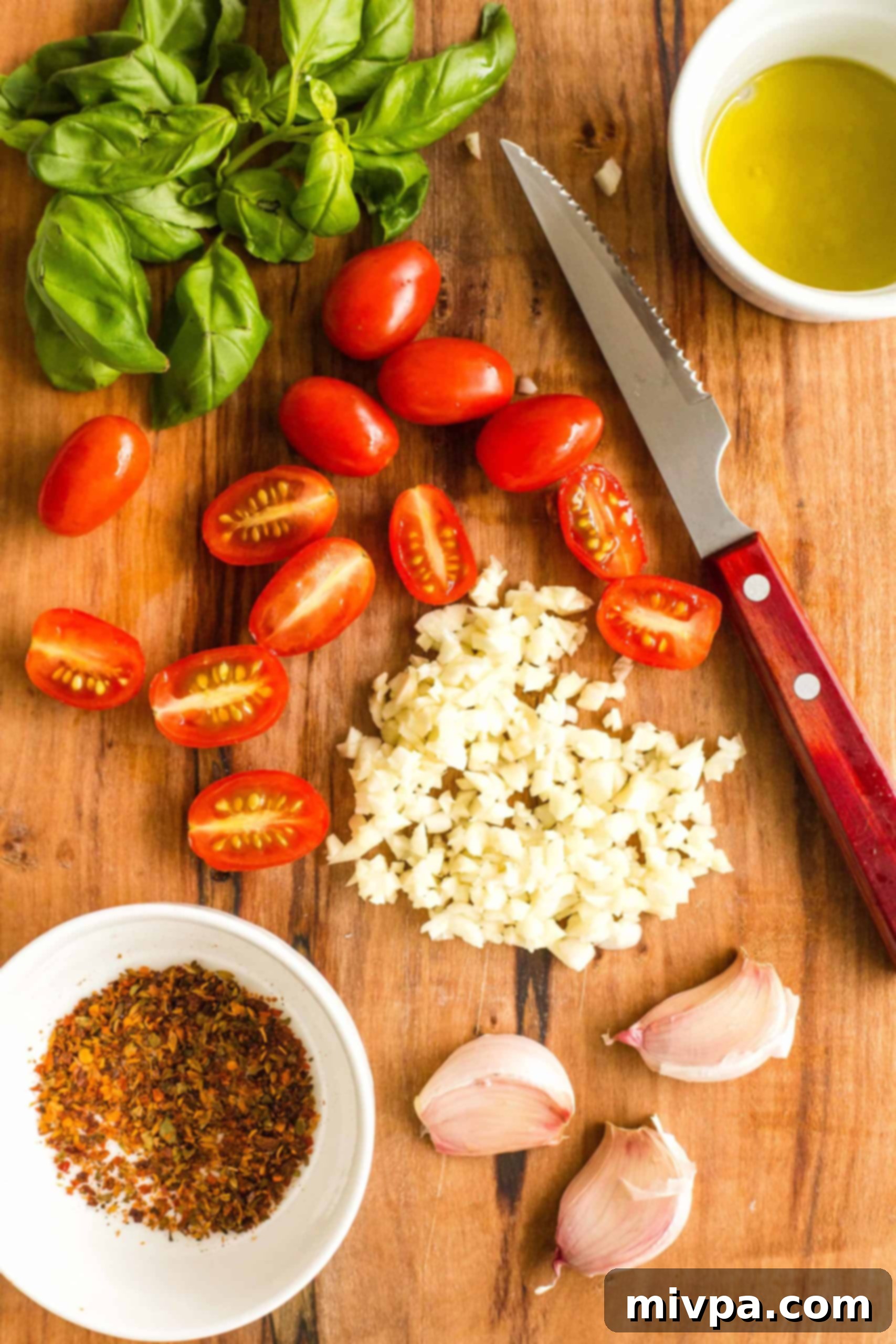Easy Caprese Pizza (Gluten-Free, Vegan) Preparing the topping ingredients for caprese pizza - basil leaves, cherry tomatoes, minced garlic, red chili flakes, olive oil.