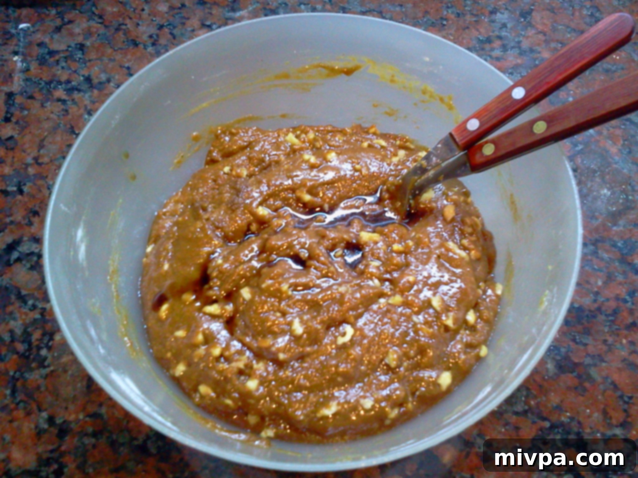 Vanilla extract being poured into the cookie dough, ready to be mixed.
