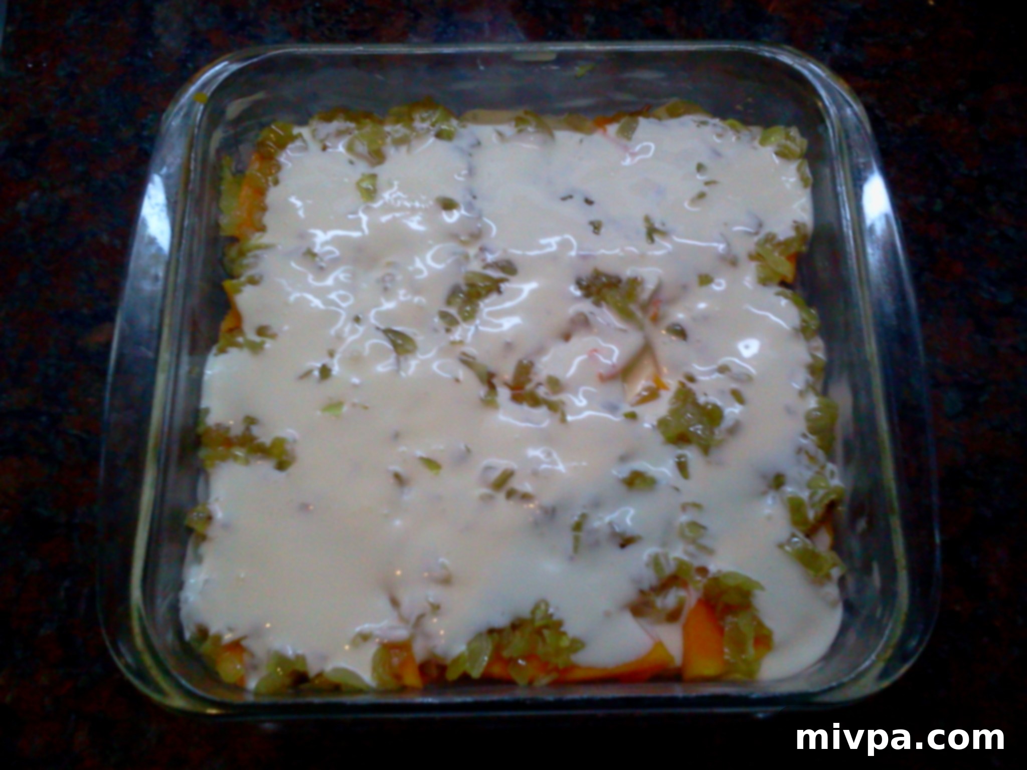 Pouring 100ml of milk cream over the layer of caramelized onions and butternut squash