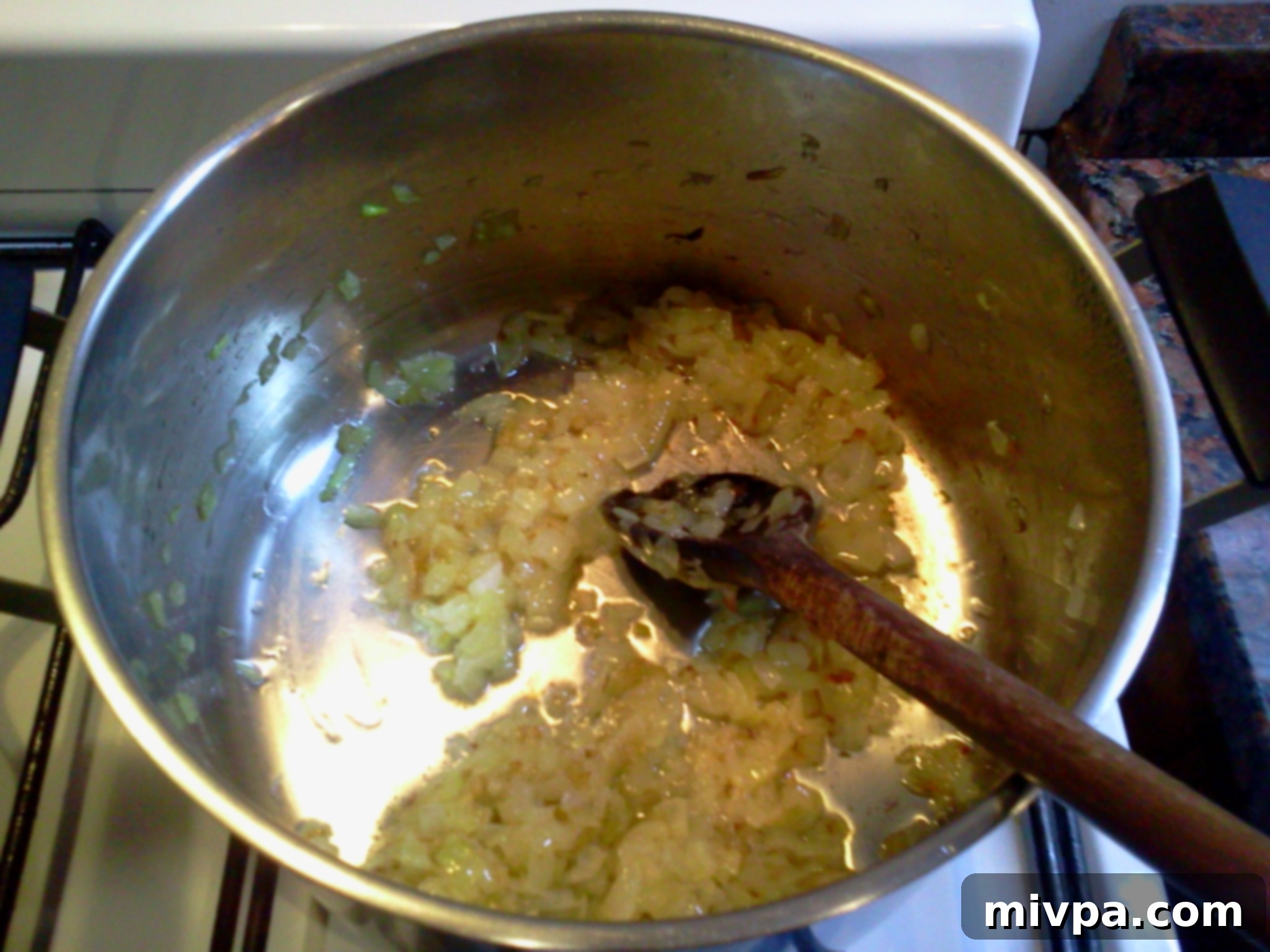 Onions being stir-fried in a pan, gradually turning a rich golden caramel brown as they caramelize