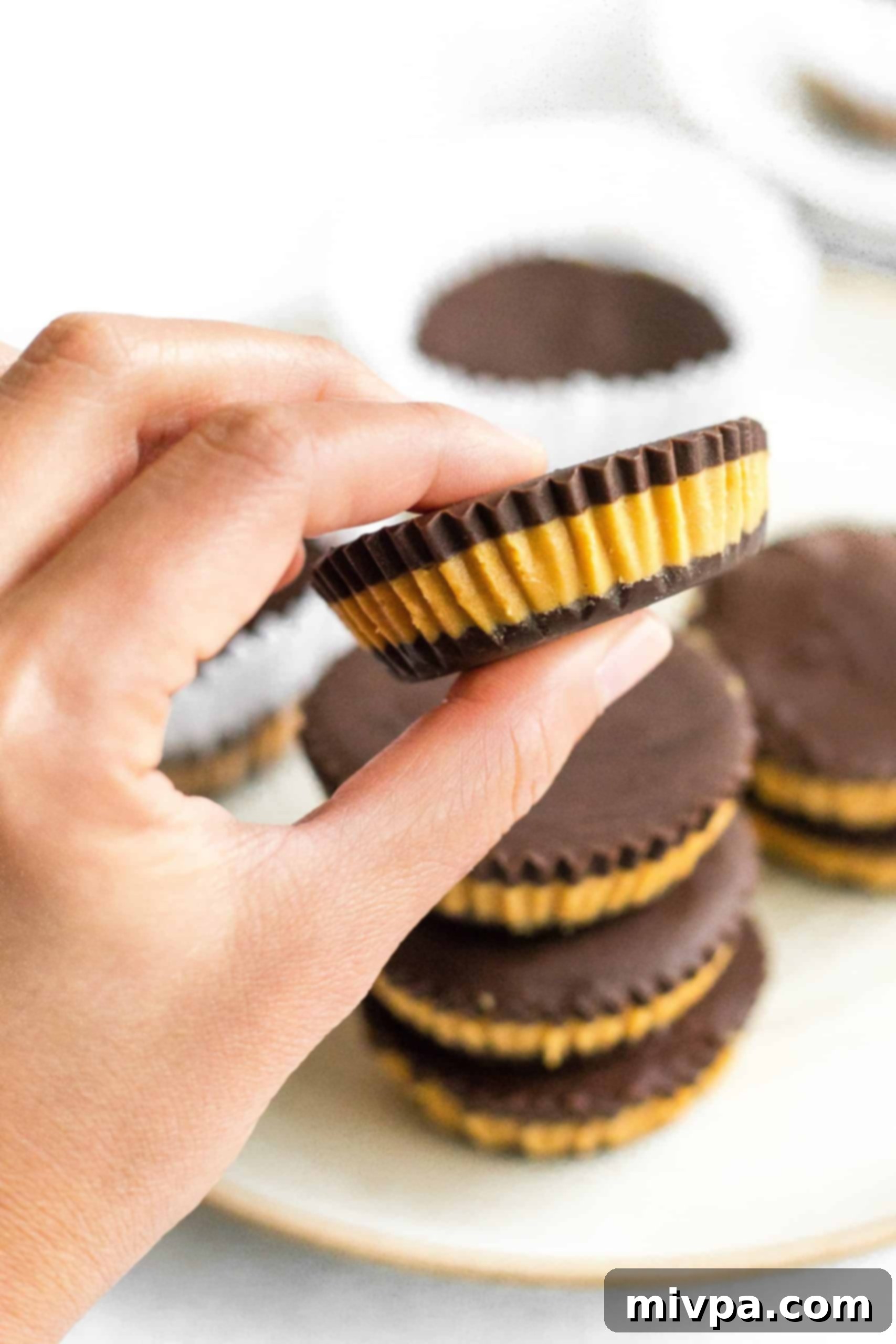 Homemade Peanut Butter Cups (Gluten-Free, Vegan) Hand holding a homemade peanut butter cup.