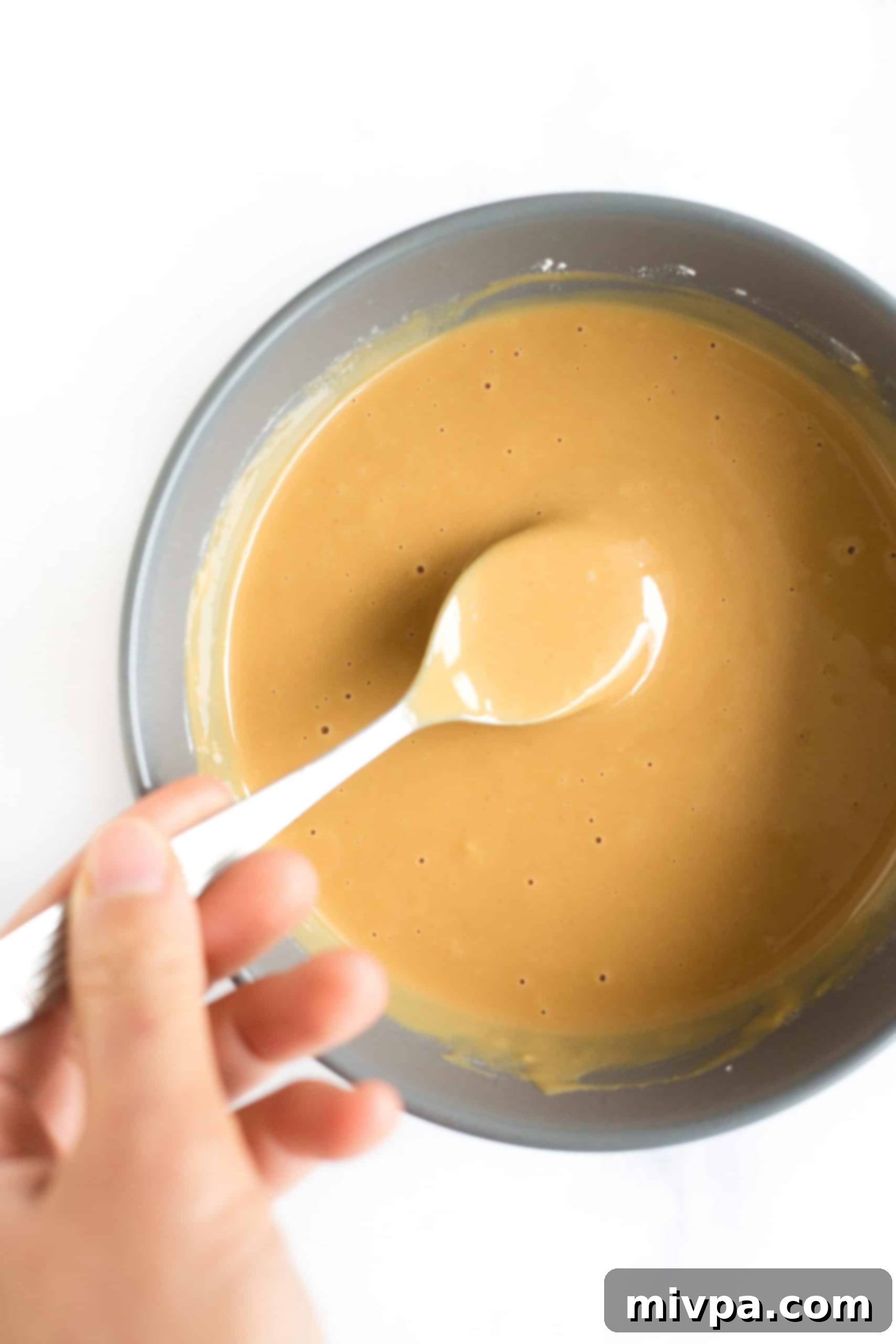 Homemade Peanut Butter Cups (Gluten-Free, Vegan) Mixing peanut butter mixture in a grey bowl.