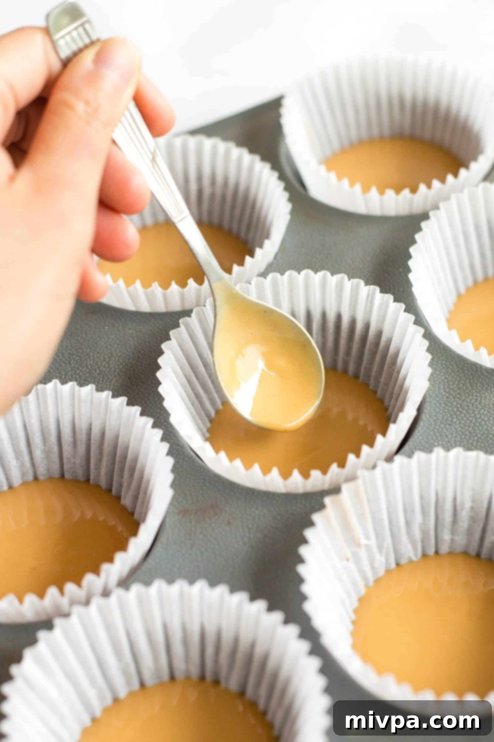 Healthy Peanut Butter Cups (Gluten-Free, Vegan) Distributing peanut butter mixture between paper muffin liners.