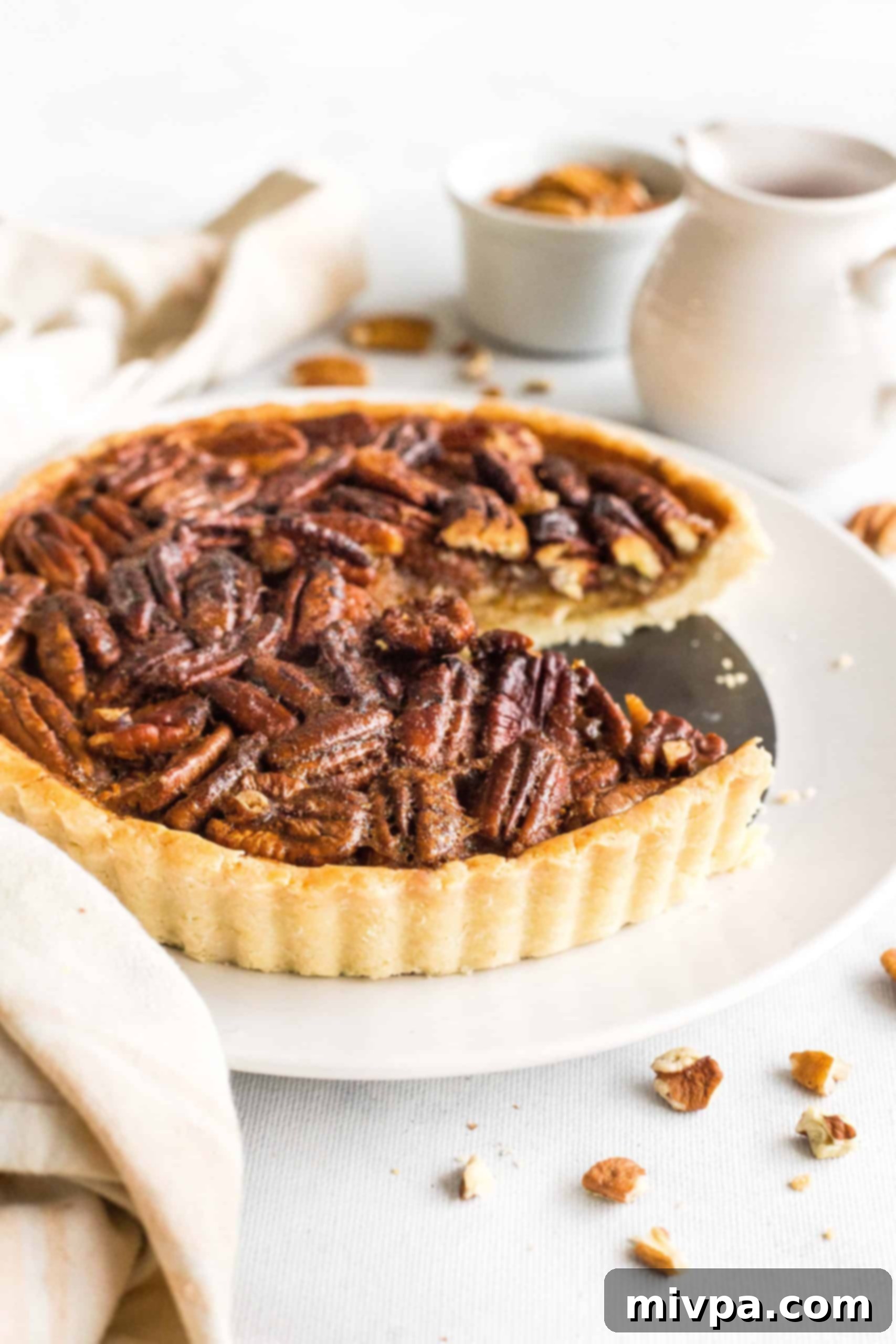 Easy Gluten-Free Pecan Pie Recipe (Dairy-Free) Sliced gluten-free pecan pie on a white plate.
