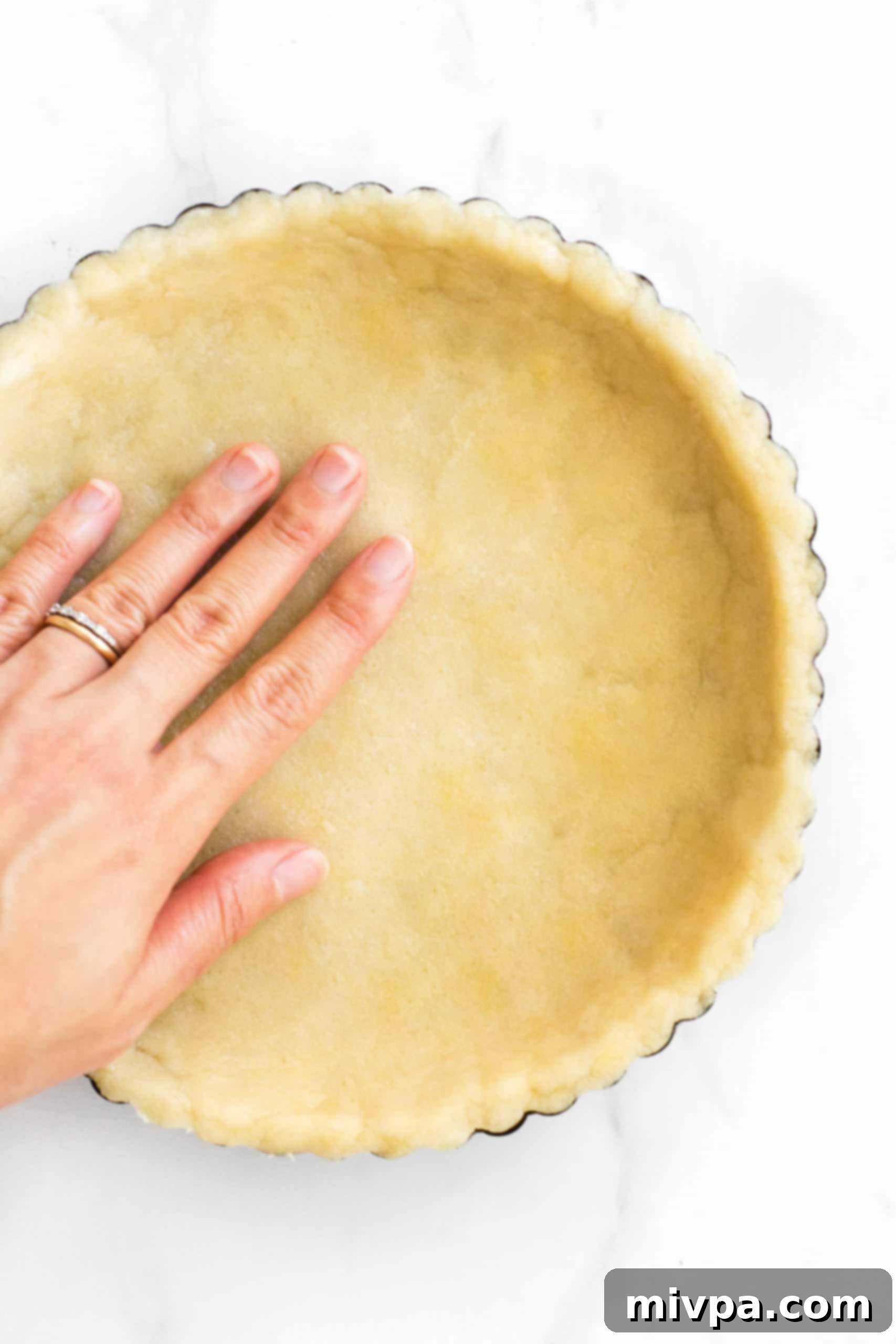 Easy Pecan Pie Recipe (Gluten-Free, Dairy-Free) Pressing gluten-free pie crust dough into a pie tin.