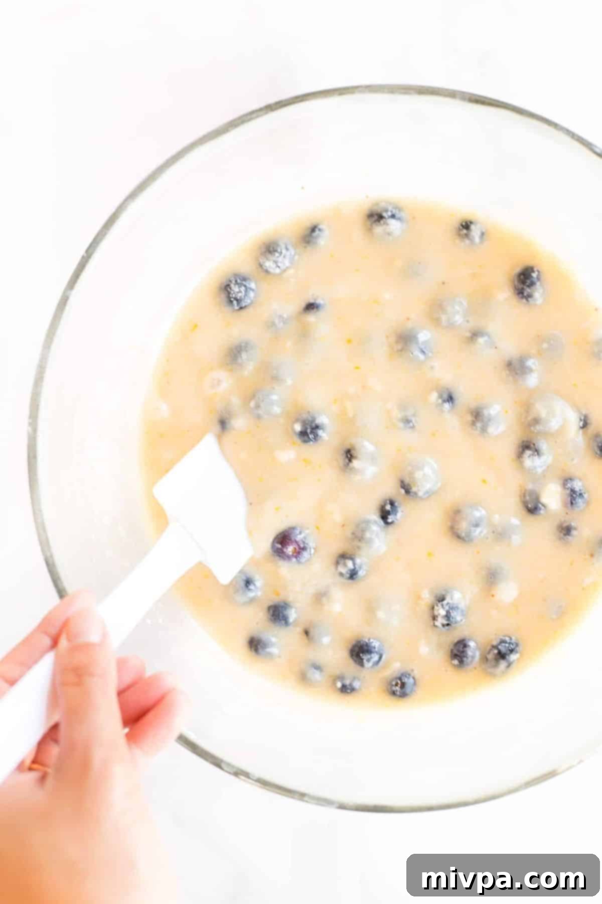 Folding blueberries into muffin batter