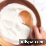 Crafting Your Own Gluten Free Vegan Buckwheat Flour 2 Scooping buckwheat flour from a wooden bowl
