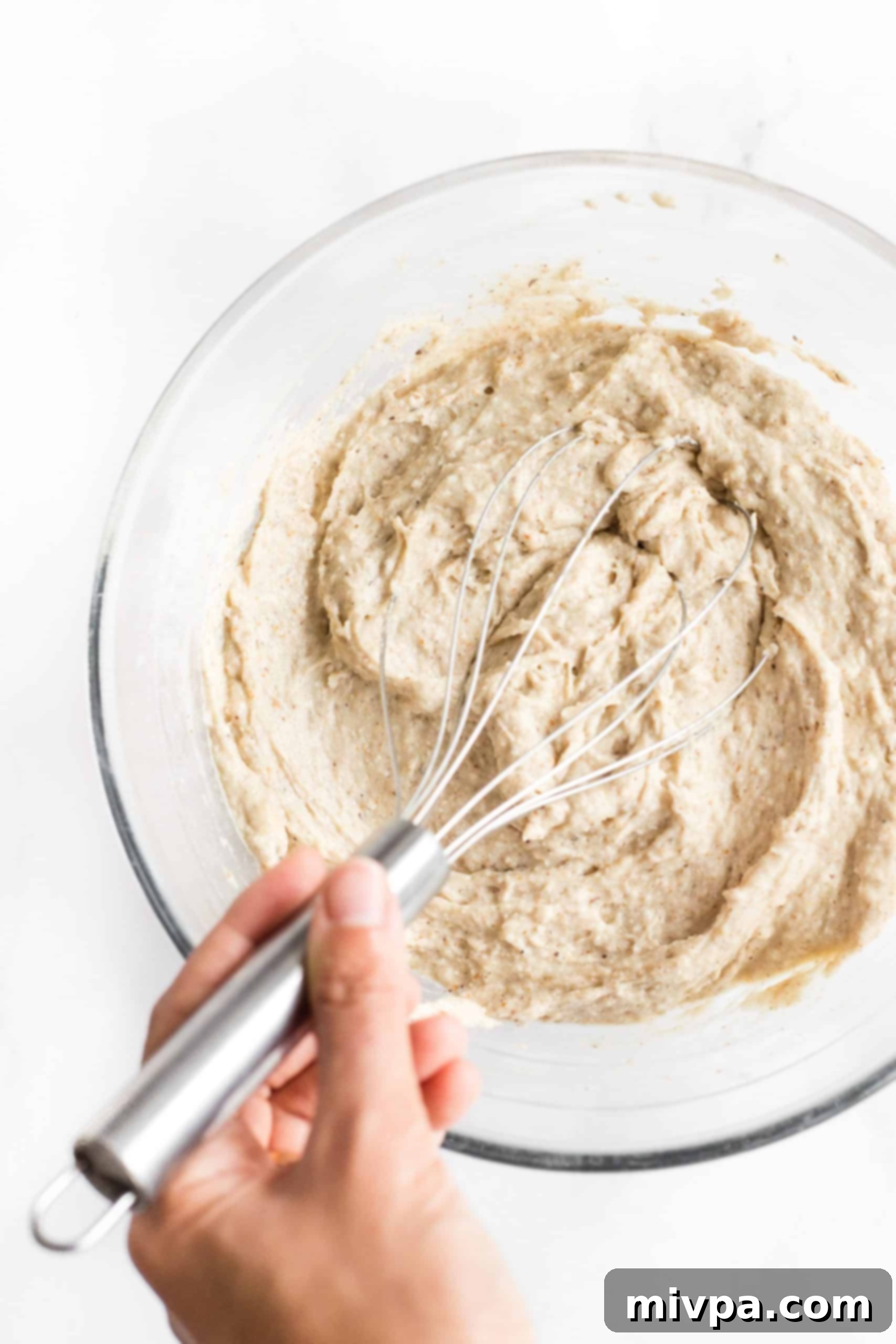 Mixing bread dough in a glass bowl.