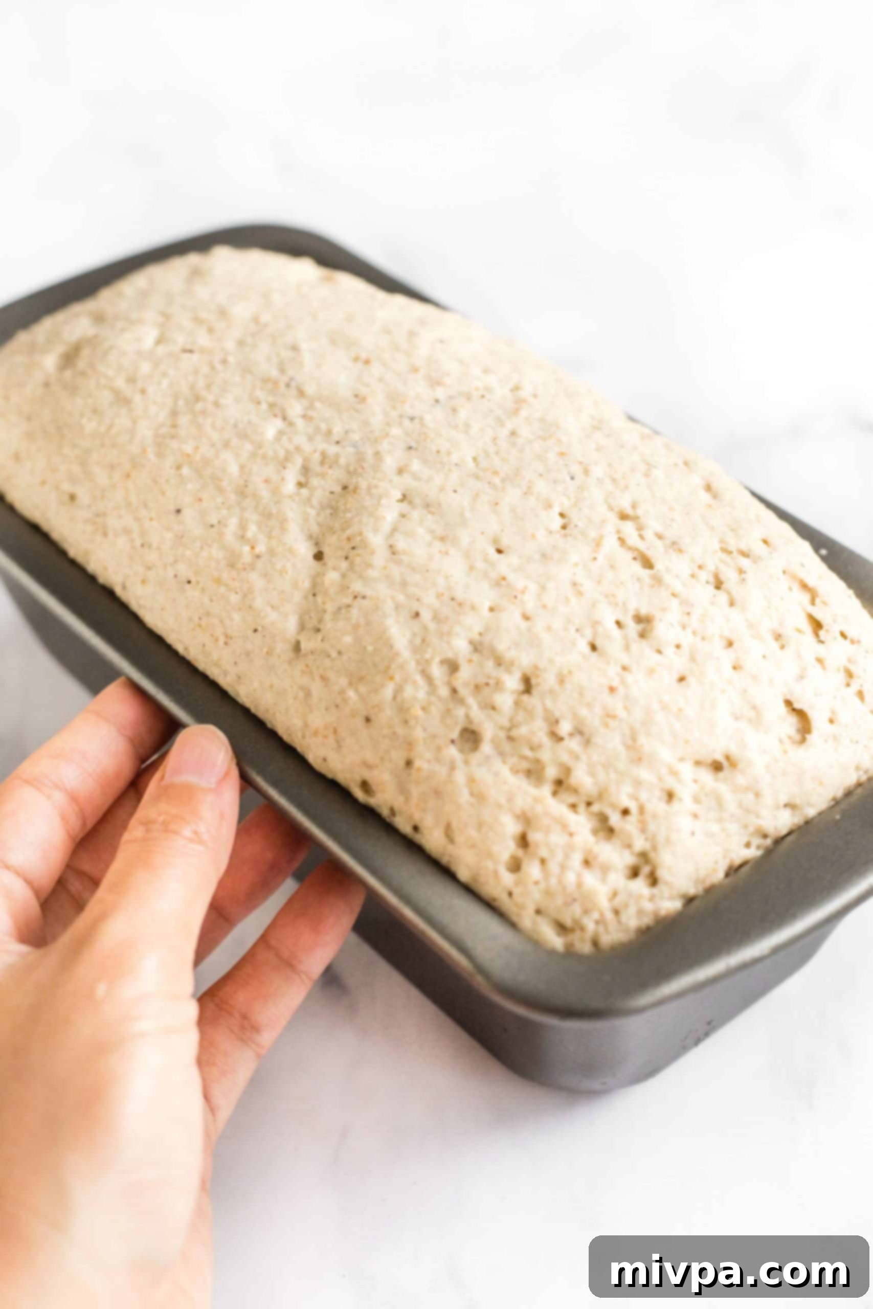 Holding a pan with unbaked bread dough.