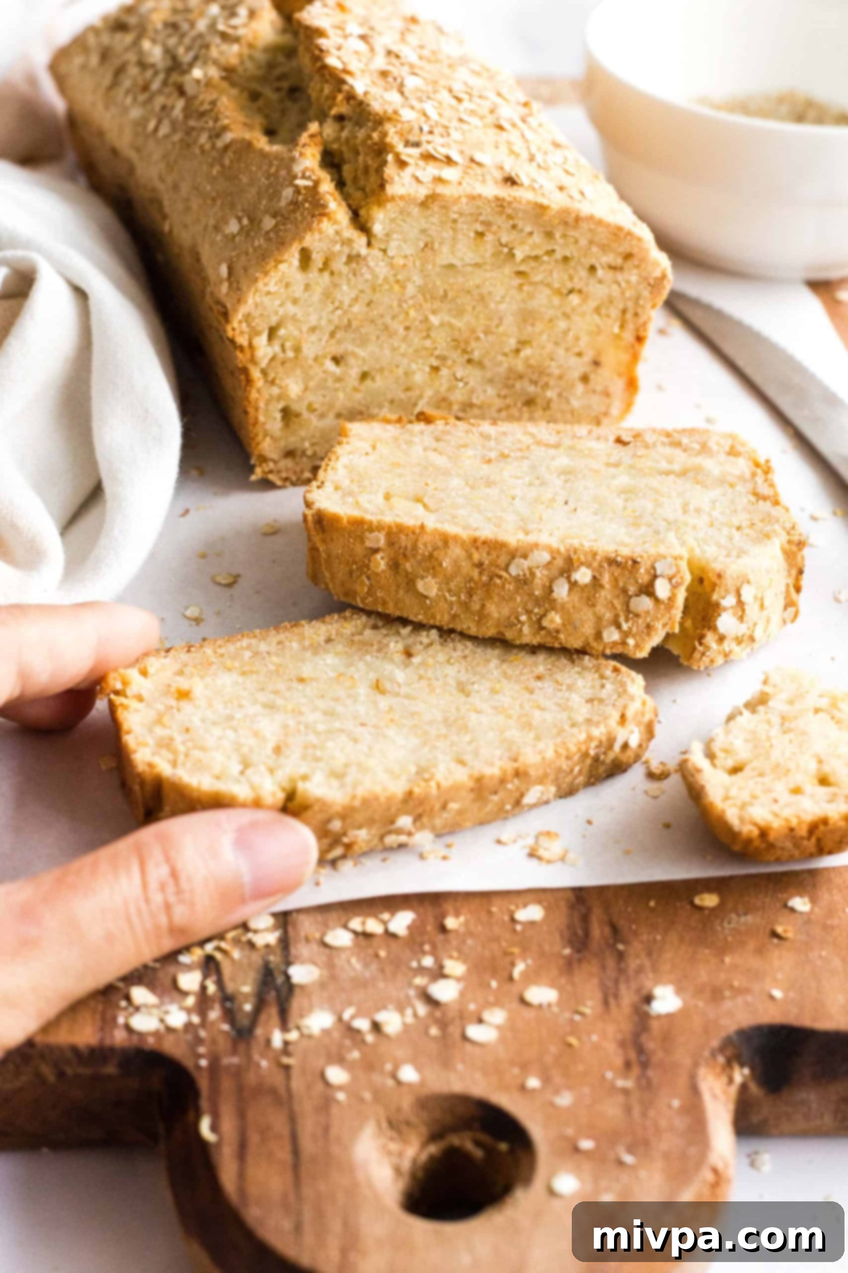 Hand reaching for a slice of quinoa bread.