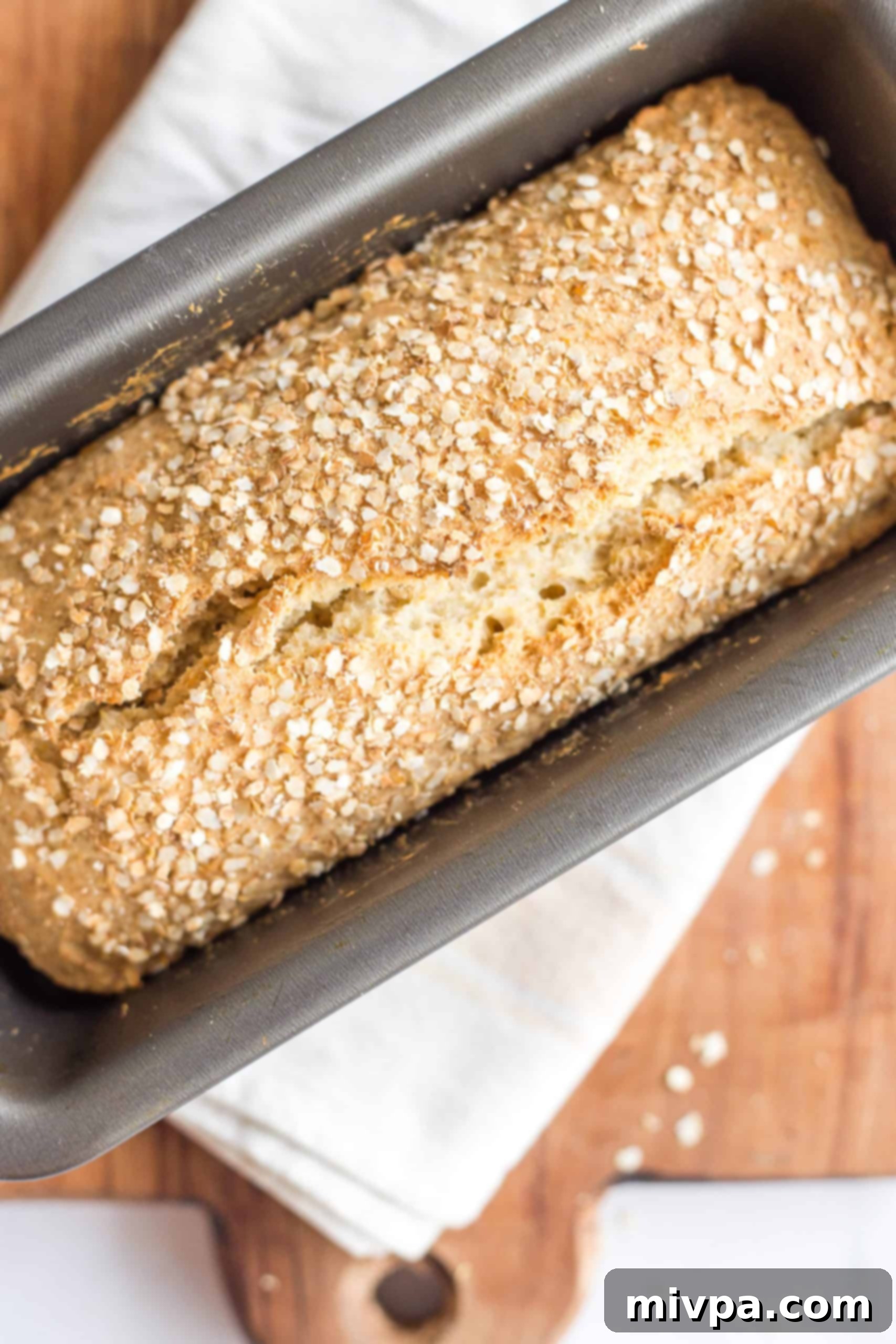 Freshly baked loaf of quinoa bread in a loaf pan.