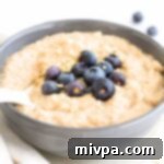 Up close view of a bowl of quinoa porridge topped with fresh blueberries