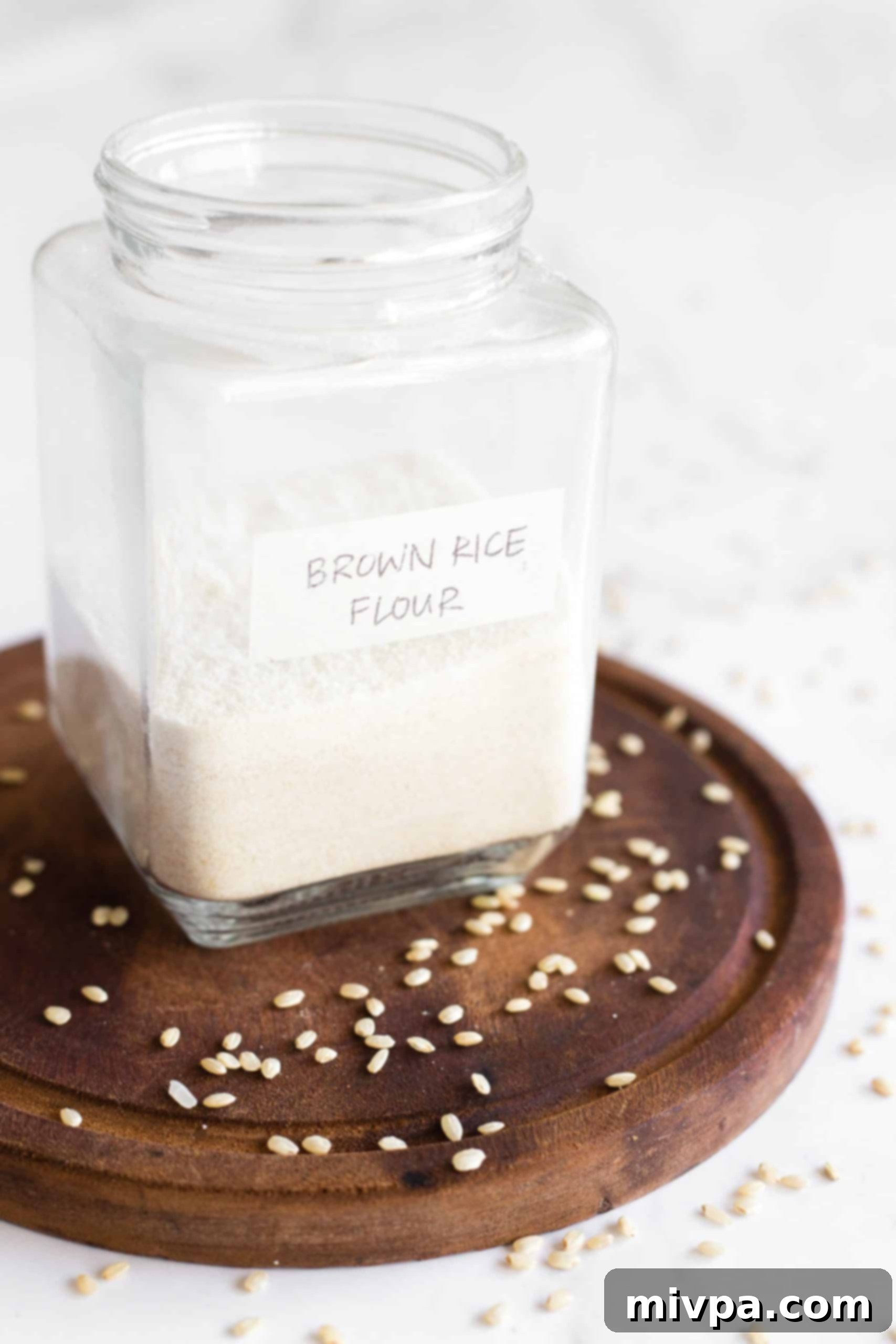 A half-filled glass jar of homemade brown rice flour, securely lidded and placed on a wooden surface for storage.