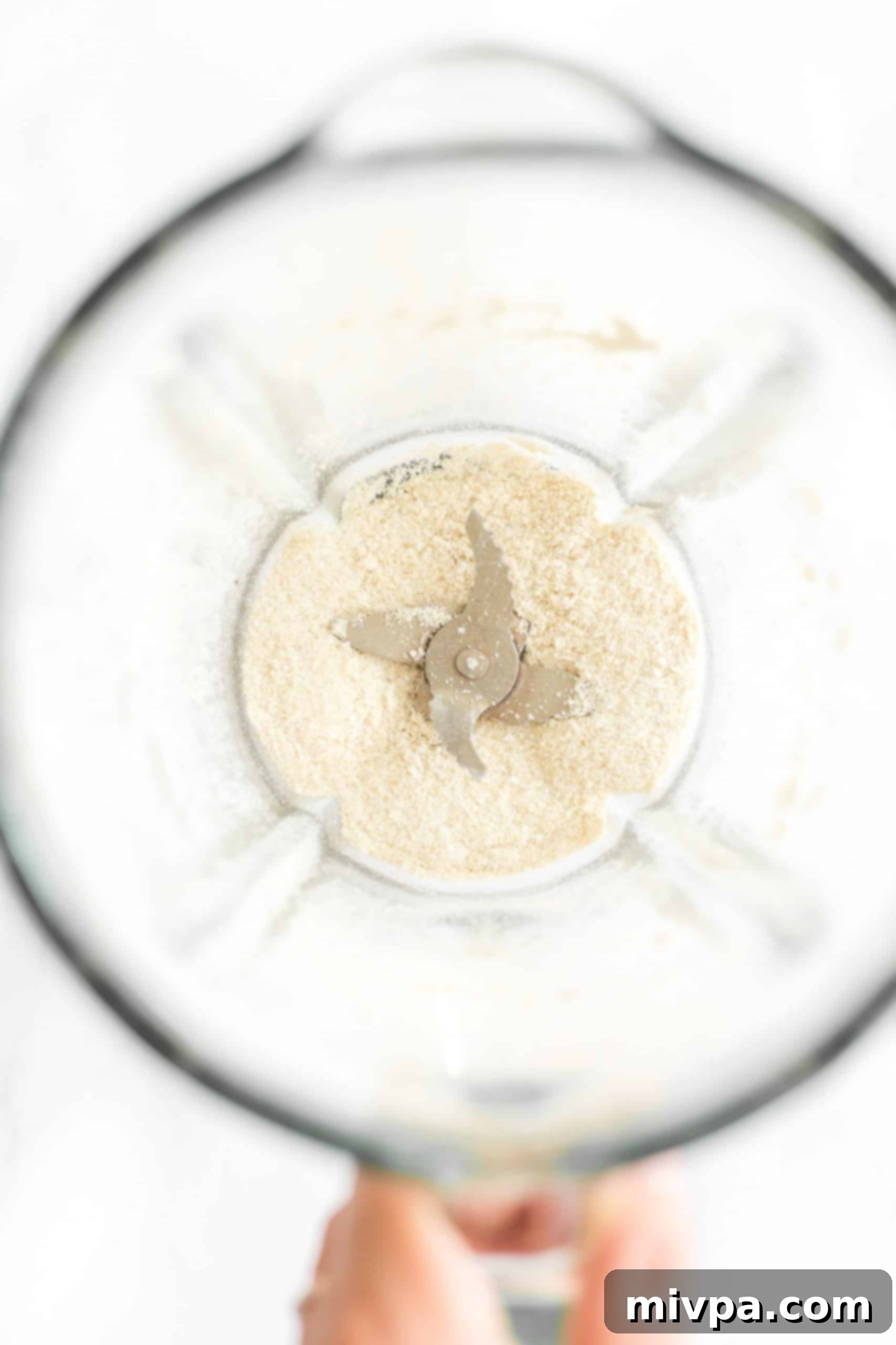 Coarsely processed rice flour visible in a blender after the first round of grinding.