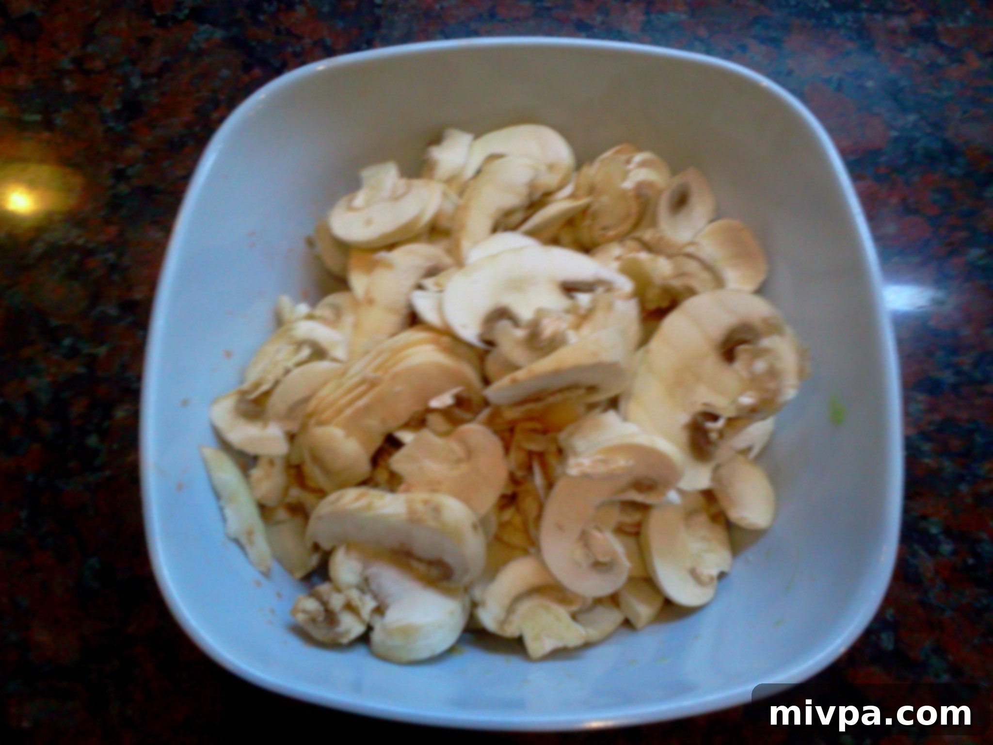 Thinly sliced white button mushrooms, prepared for cooking and ready to add texture.