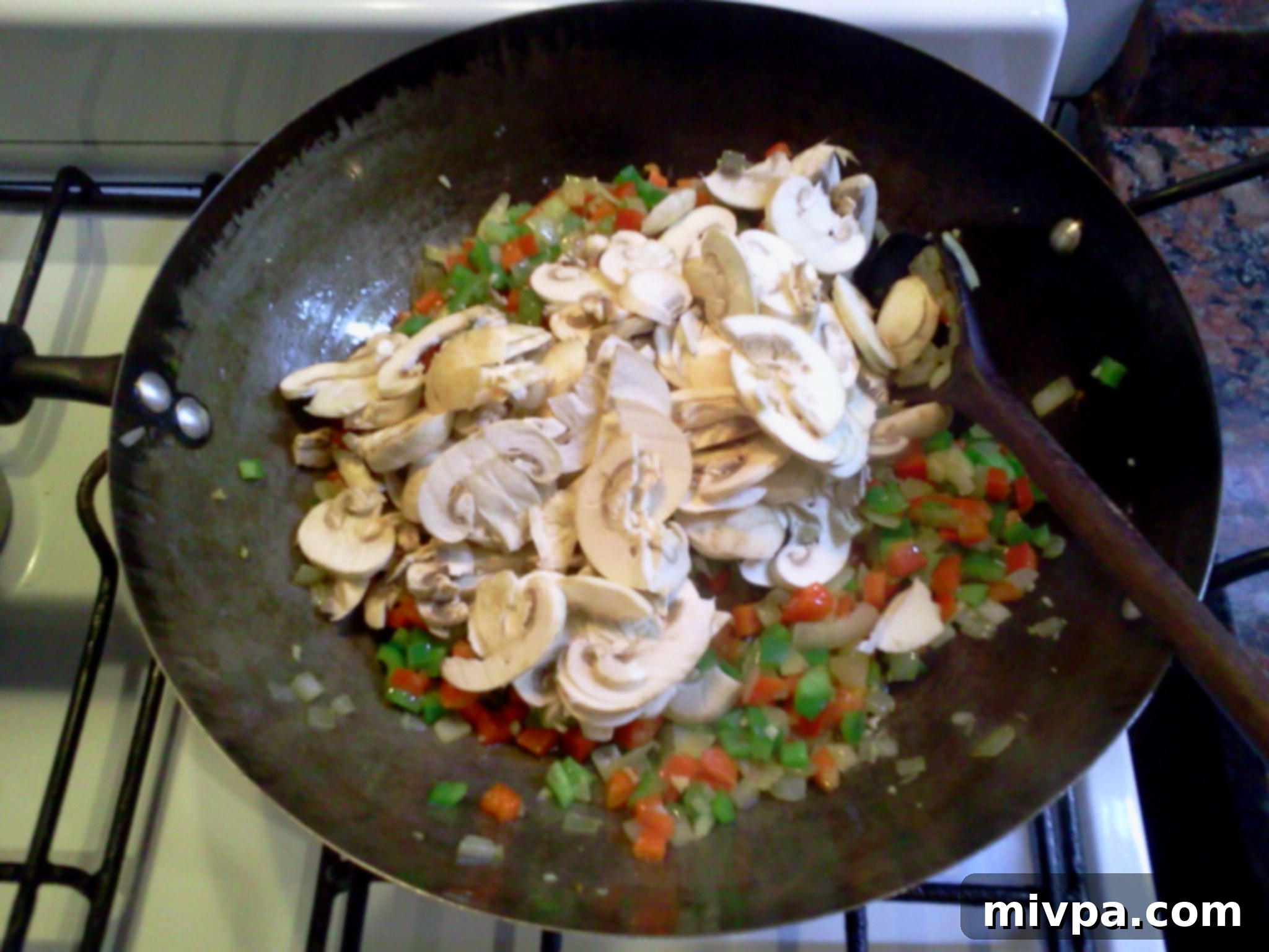 Sliced mushrooms are added to the wok with the other vegetables, ready to be stir-fried.
