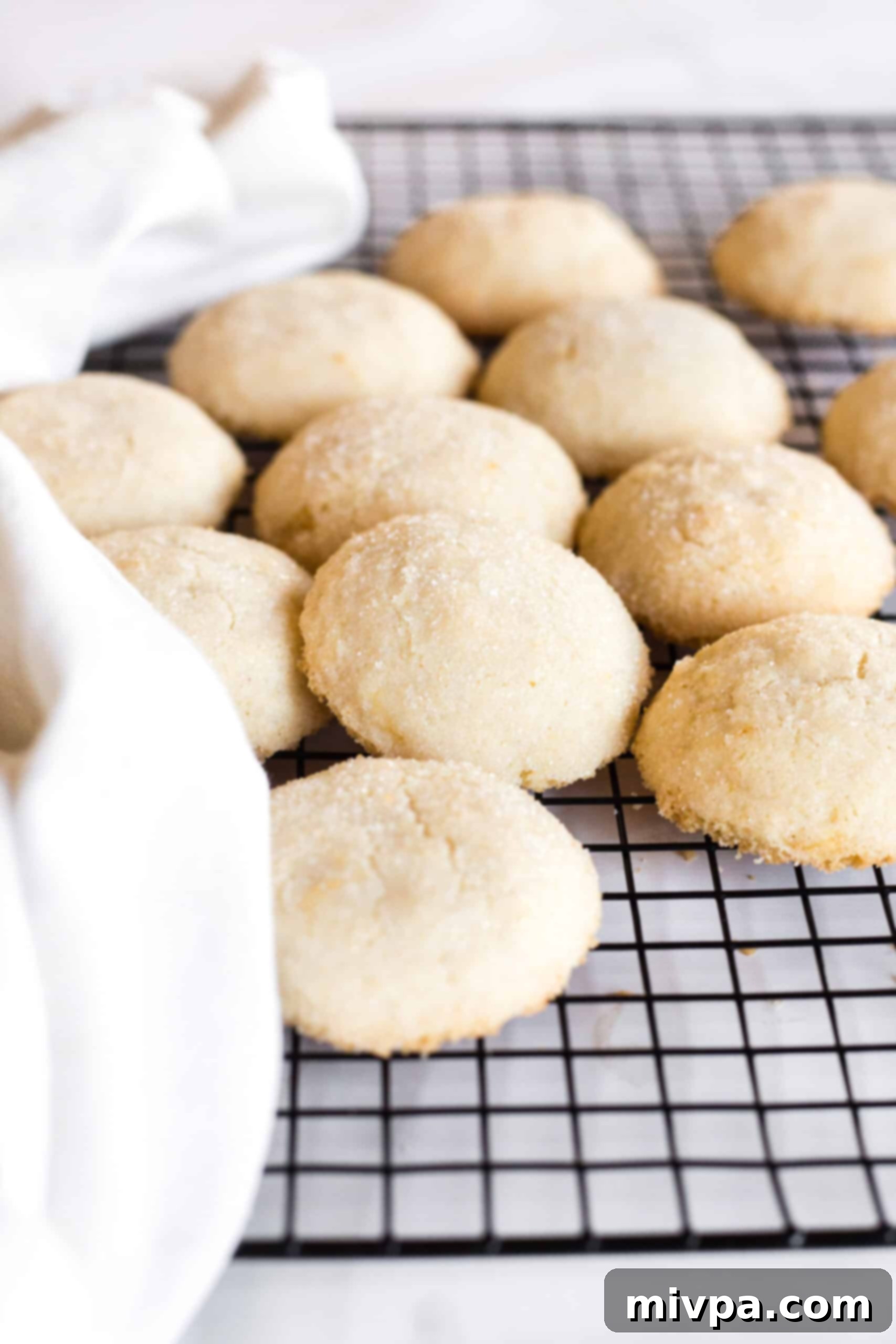 A batch of gluten-free sugar cookies cooling on a wire rack after baking.