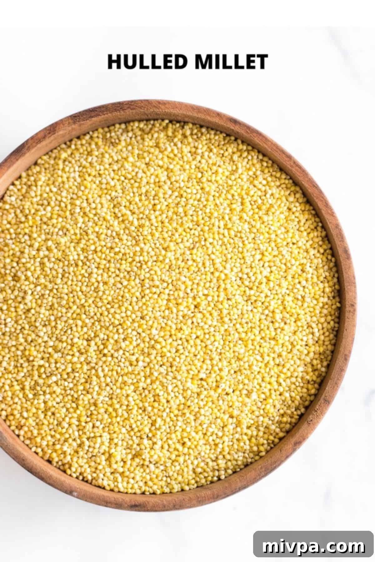 An up-close shot of hulled millet in a wooden bowl (how to make millet flour).