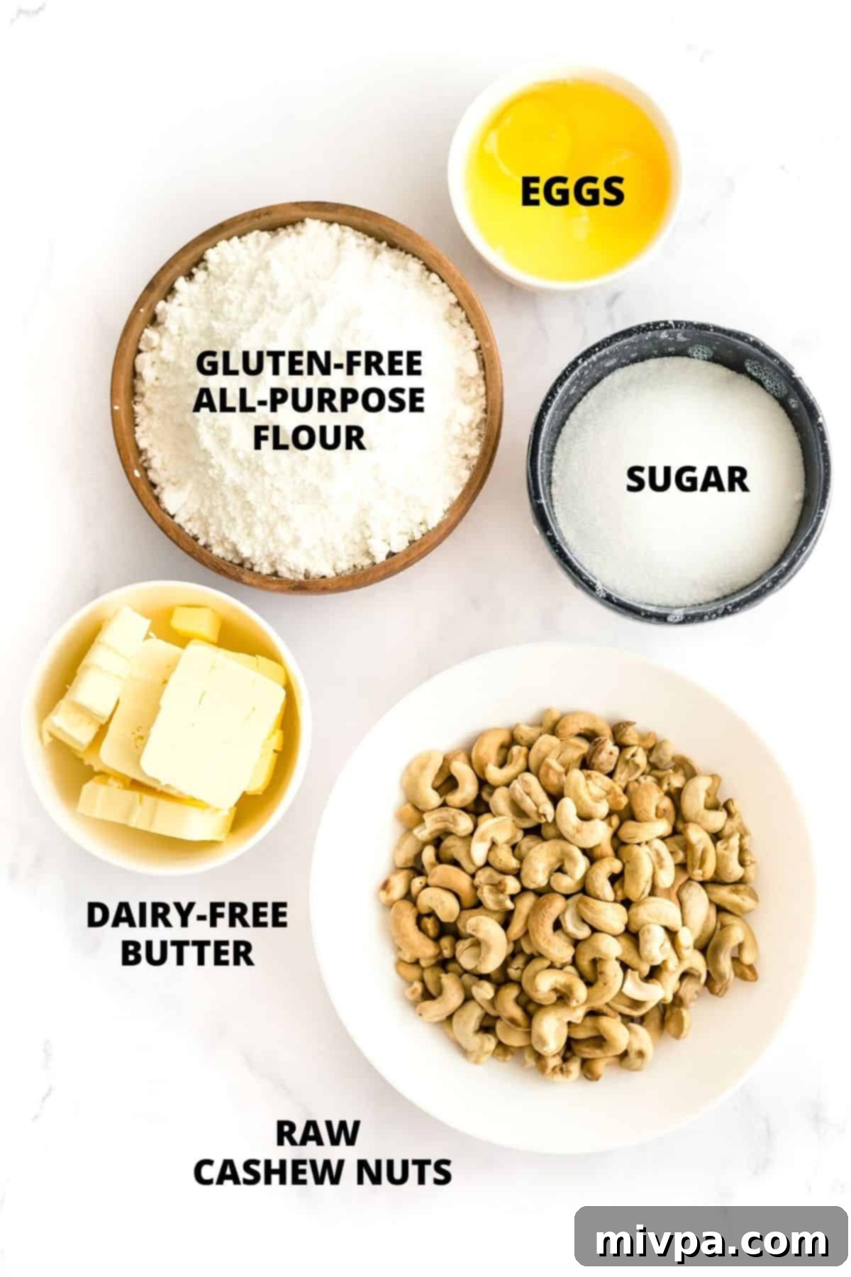 Recipe for Cashew Nut Cookies (Gluten-Free, Dairy-Free) - Essential Ingredients Ingredients for cashew nut cookies recipe laid out neatly on a marble board, including cashews, flour, sugar, and butter.
