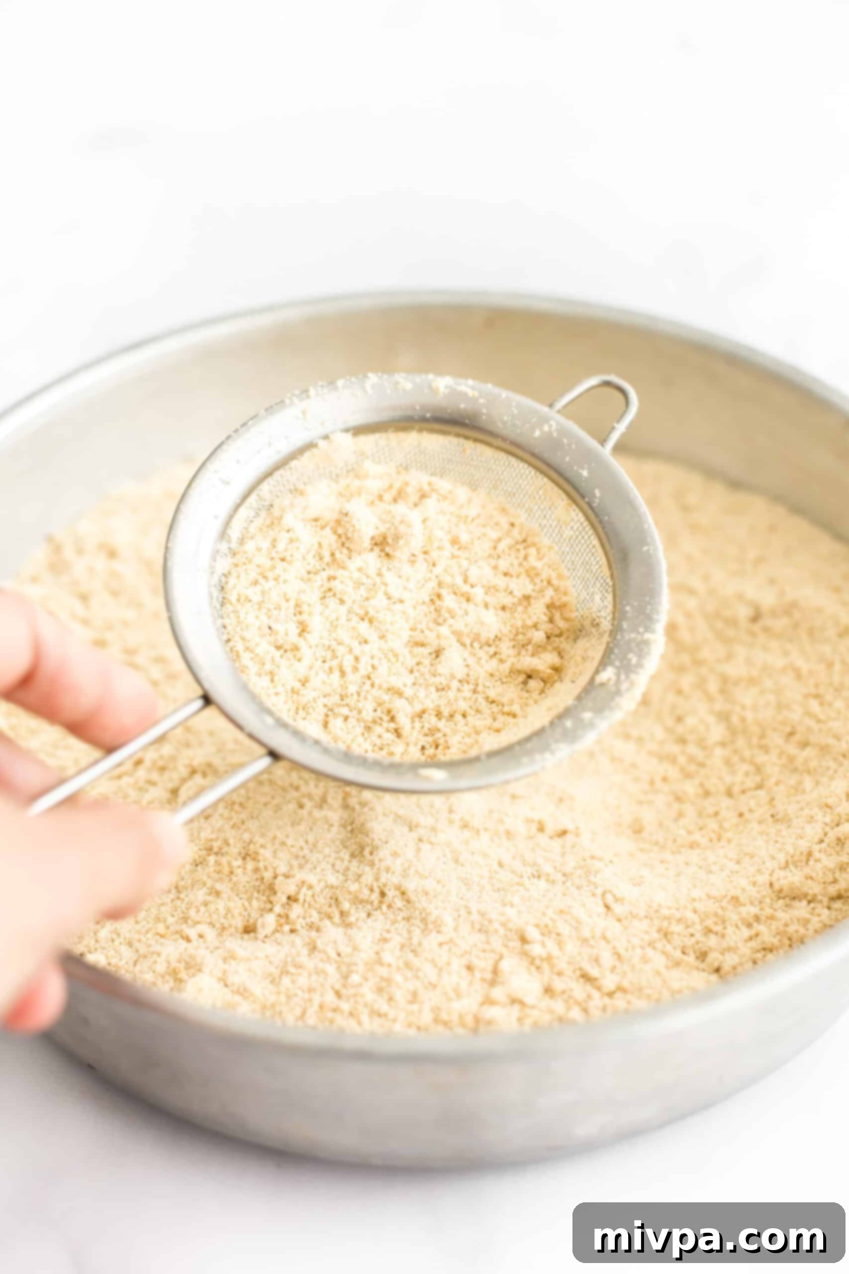 Gluten-Free Cashew Cookies (Dairy-Free) - Sifting for perfect texture Sifting cashew flour through a fine-mesh sieve to achieve a smooth consistency.