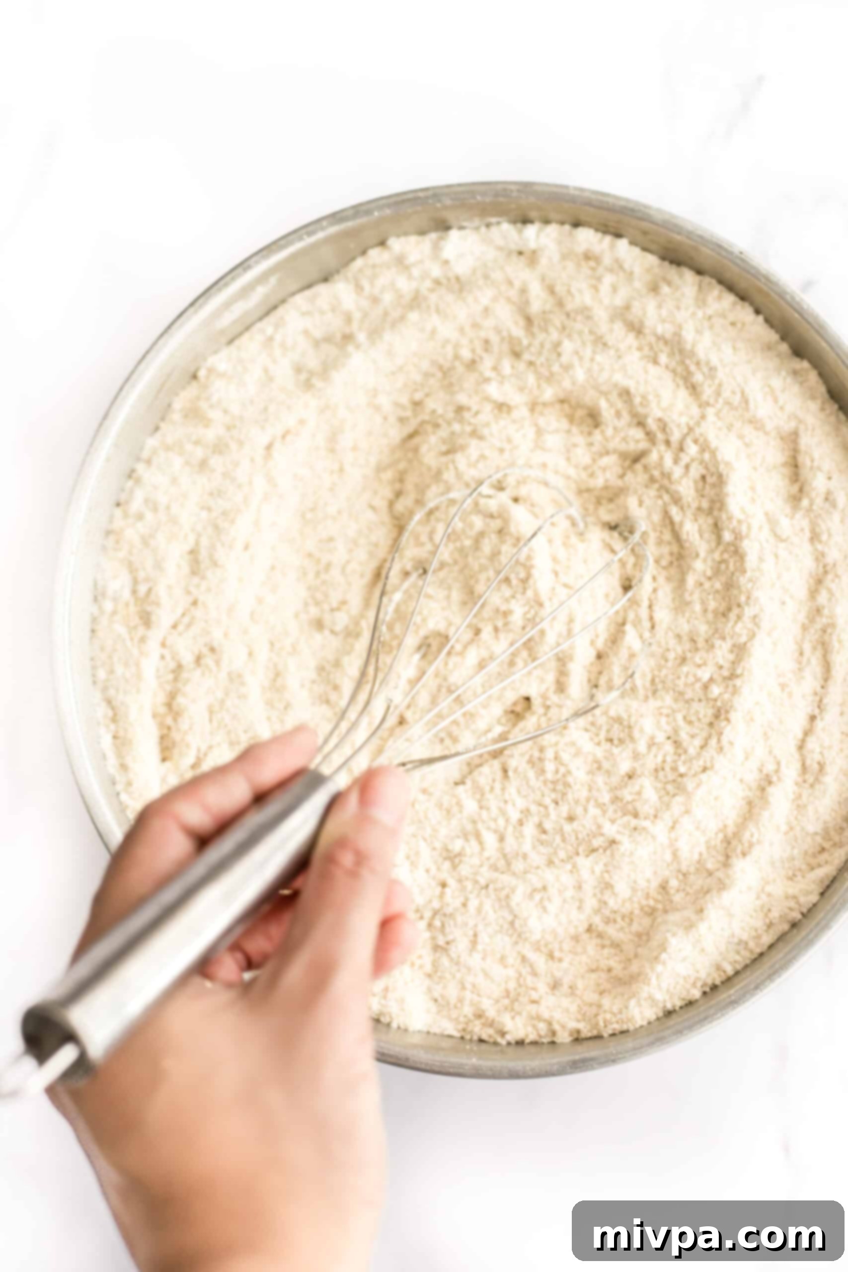Easy Cashew Nut Cookies (Gluten-Free, Dairy-Free) - Combining dry ingredients Whisking flour mixture in a large metal bowl, combining cashew flour, gluten-free flour, and sugar.