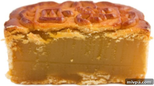 A cross-section of a mooncake, revealing the rich lotus paste filling and a salted duck egg yolk.