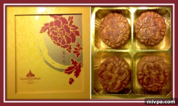 Goodwood Park Hotel's famous mooncakes in their elegant golden box, decorated with a red lotus flower.
