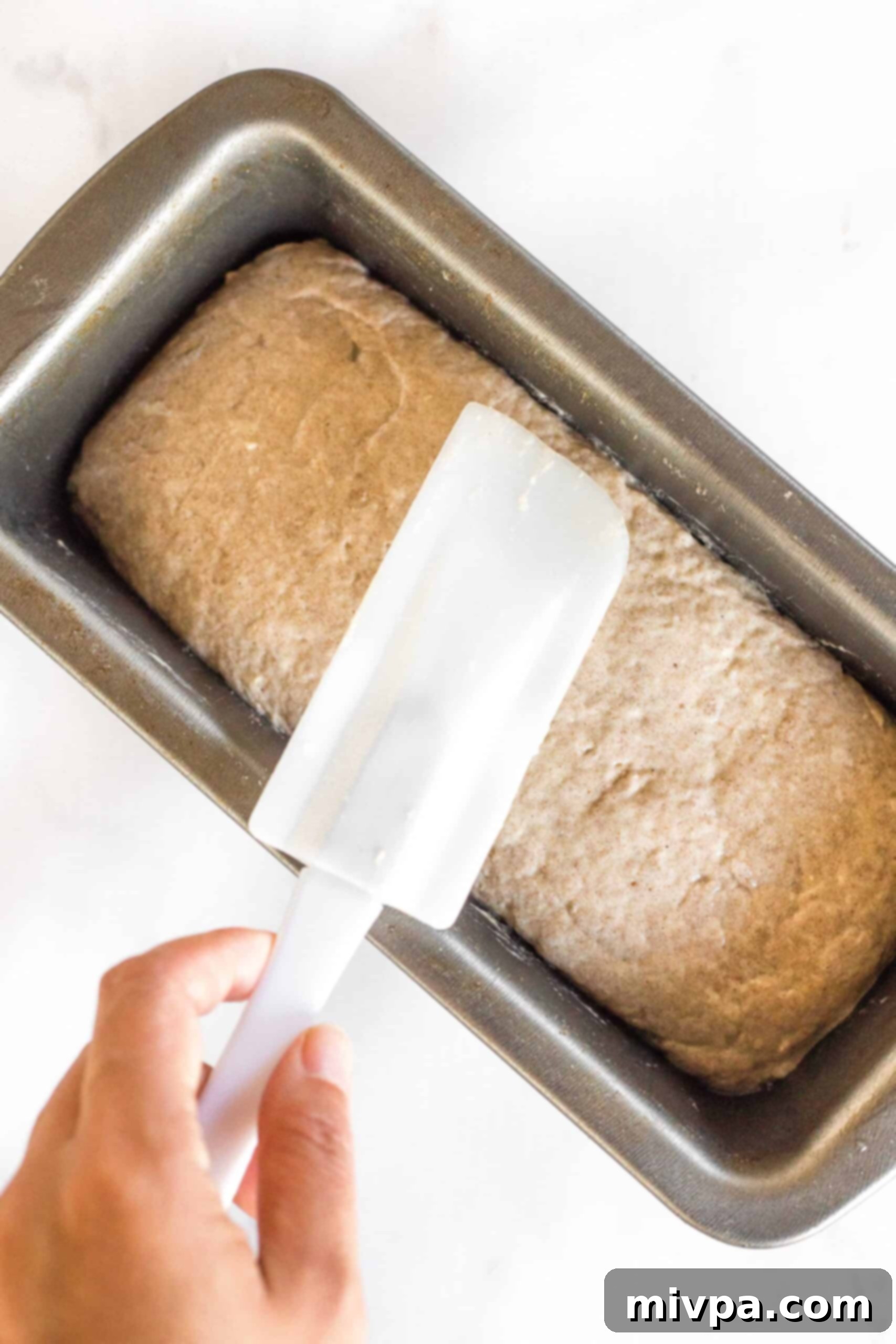 Soft, Fluffy Teff Bread (Gluten-Free, Dairy-Free) Smoothing out teff bread dough with spatula.