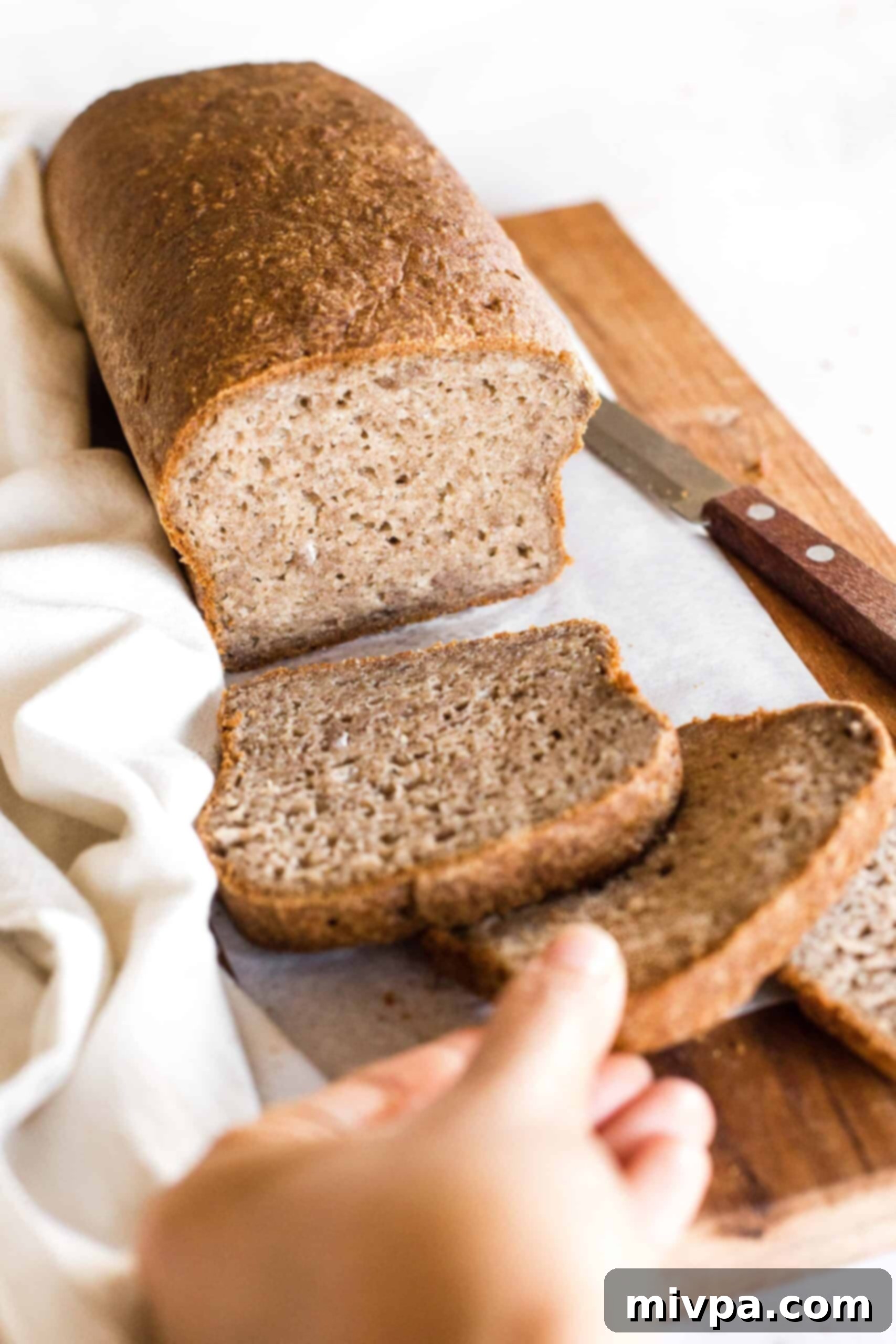 Soft, Fluffy Teff Bread (Gluten-Free, Dairy-Free) Reaching for a slice of teff bread.