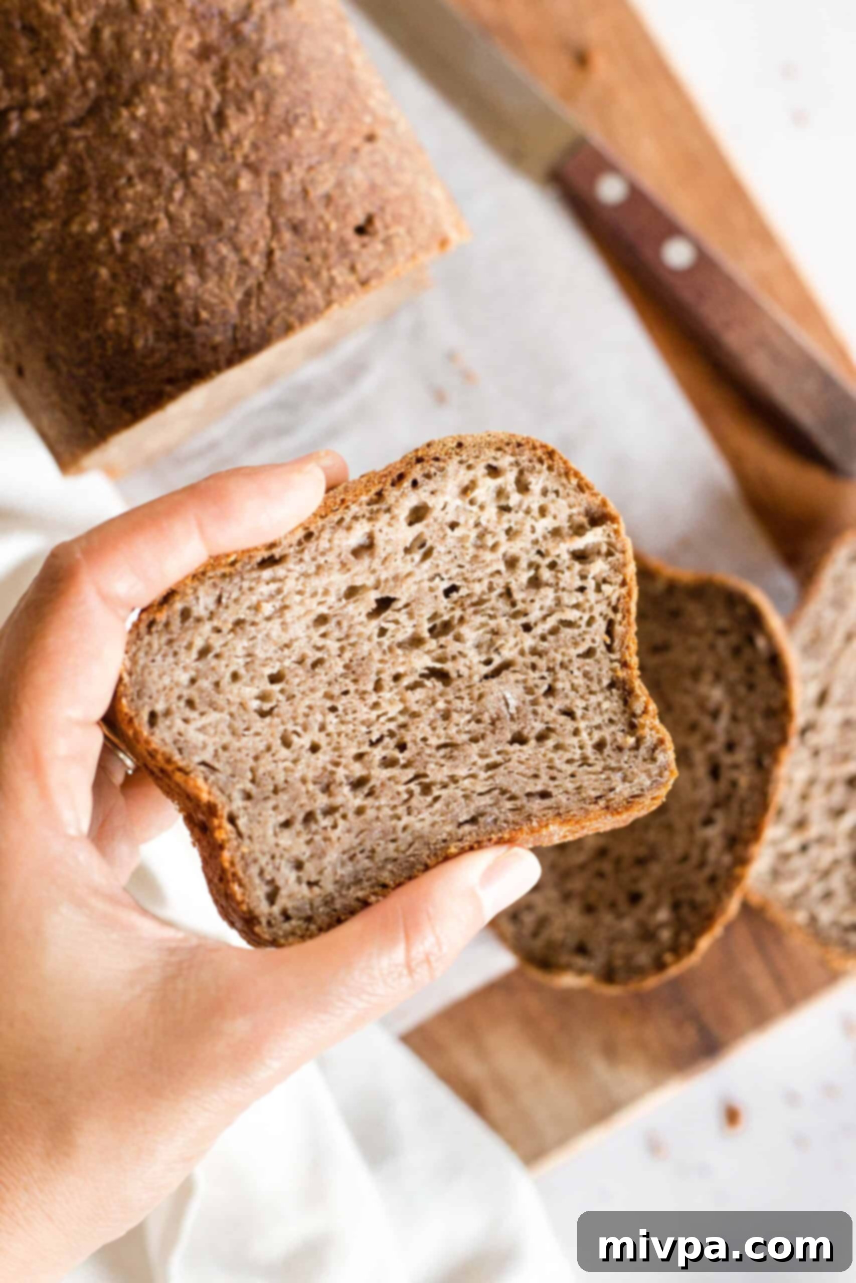 Soft, Fluffy Teff Bread (Gluten-Free, Dairy-Free) Holding up a slice of teff bread.