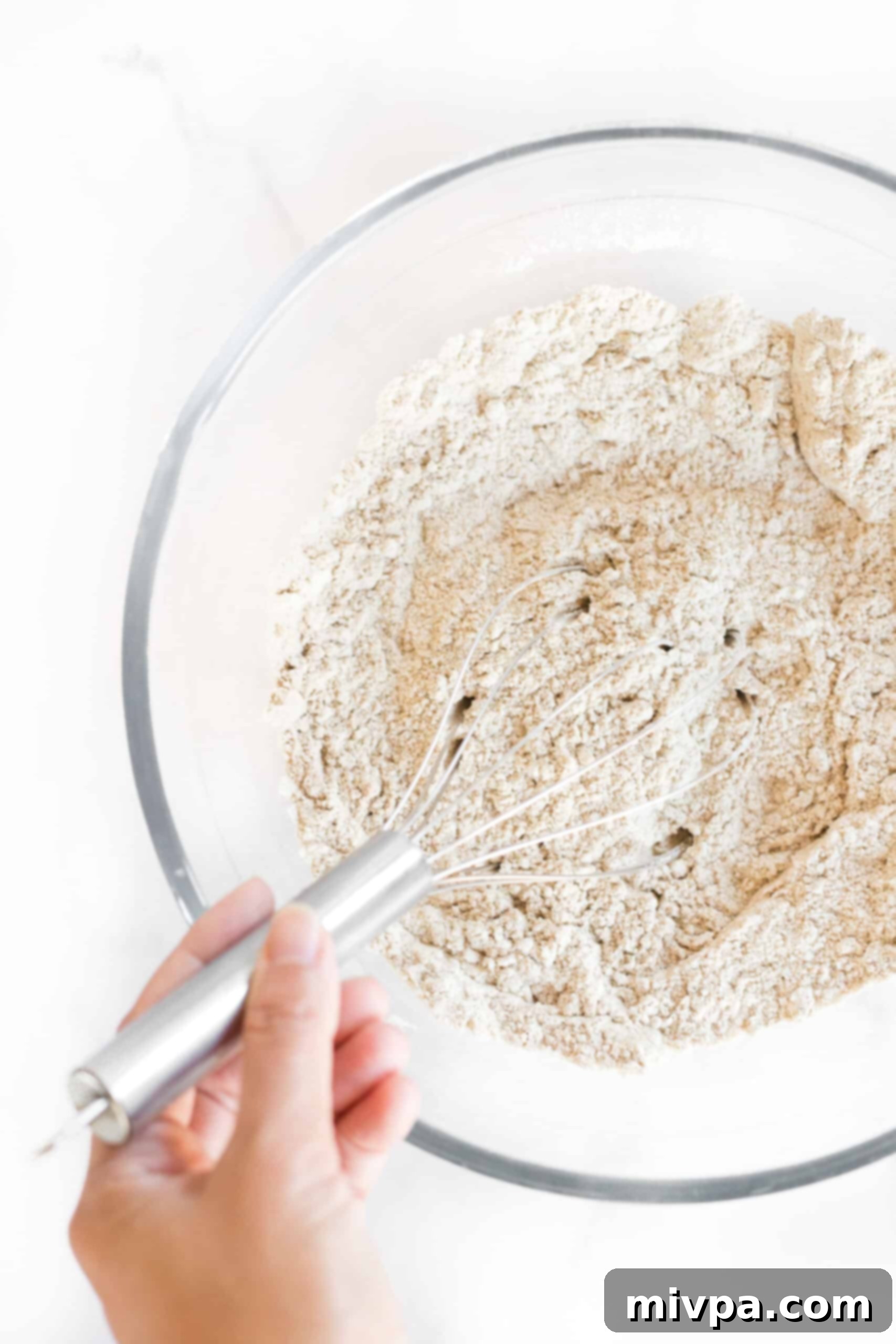 Whisking flour mixture in glass mixing bowl.