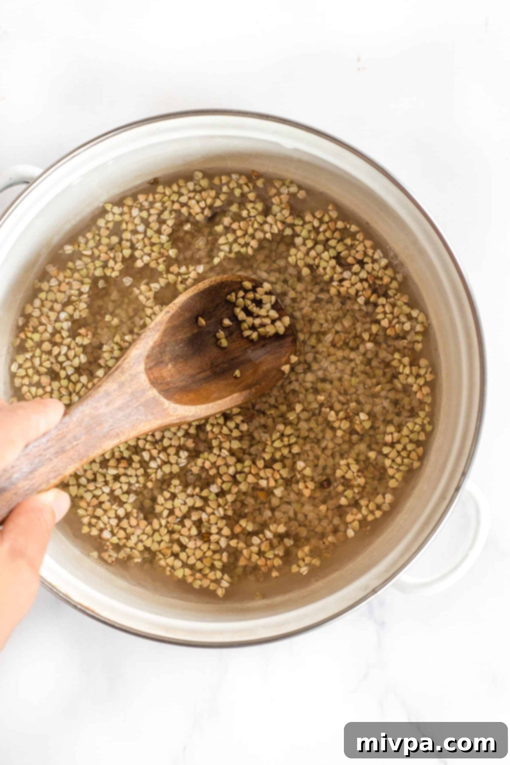 Easy Buckwheat Porridge (Gluten-Free, Vegan) Mixing buckwheat groats and water in a small pot.