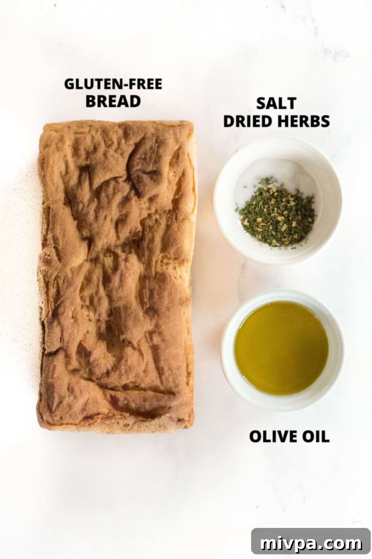A colorful array of ingredients laid out for making homemade gluten-free croutons, including bread, olive oil, and various dried herbs.