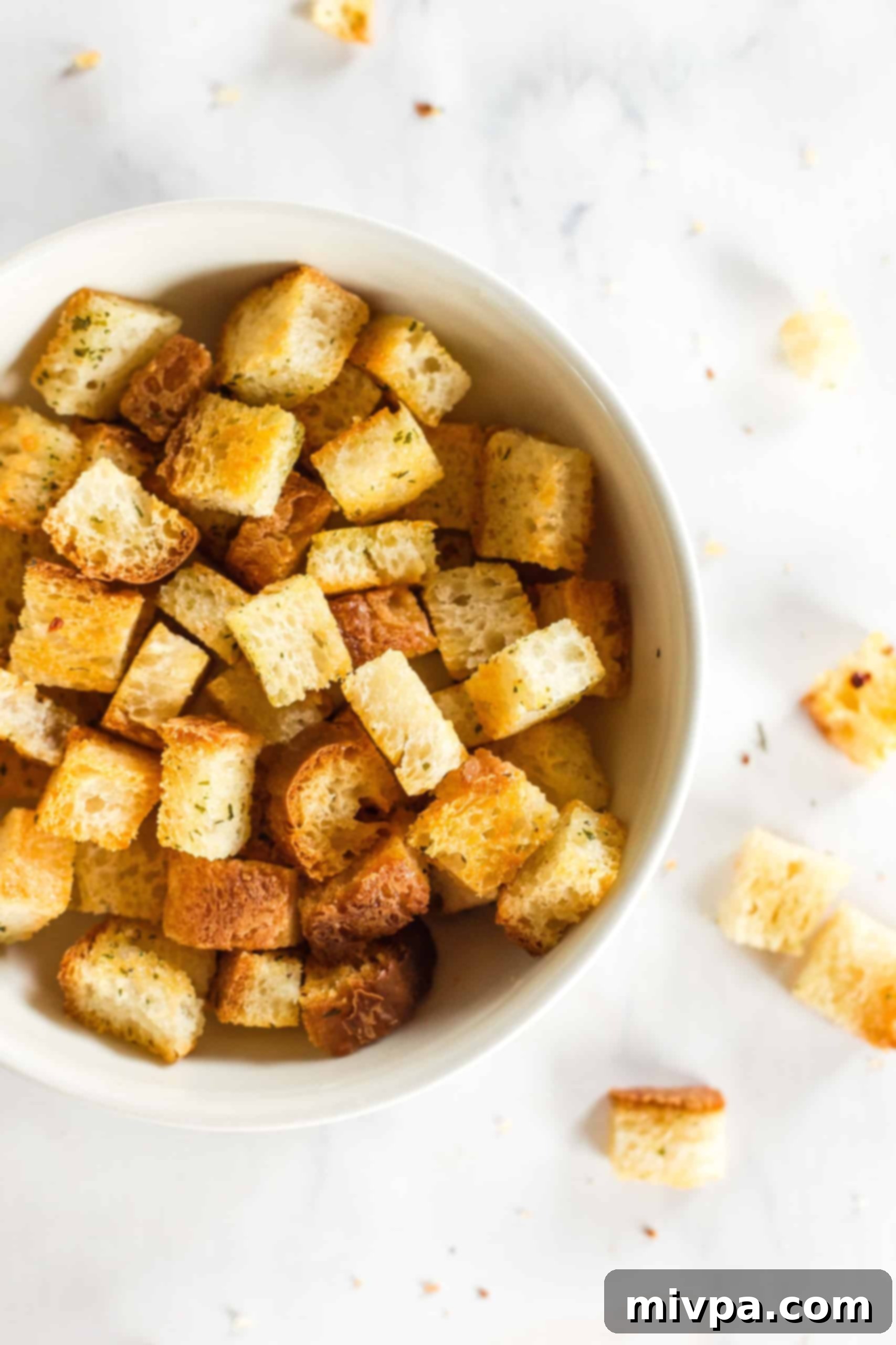 A white bowl filled with crunchy gluten-free croutons, ready to be enjoyed or stored.