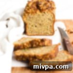 A freshly baked slice of gluten-free dairy-free zucchini bread with walnuts.