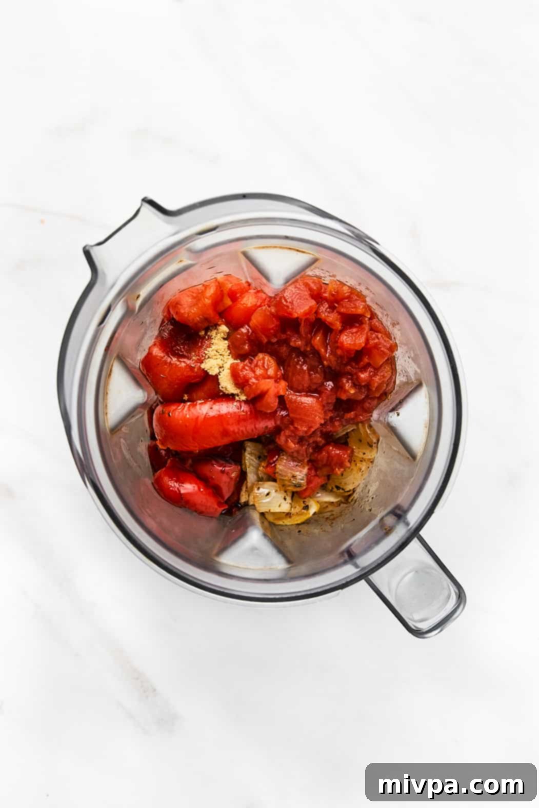 Sautéed vegetables in the bowl of a high speed blender.