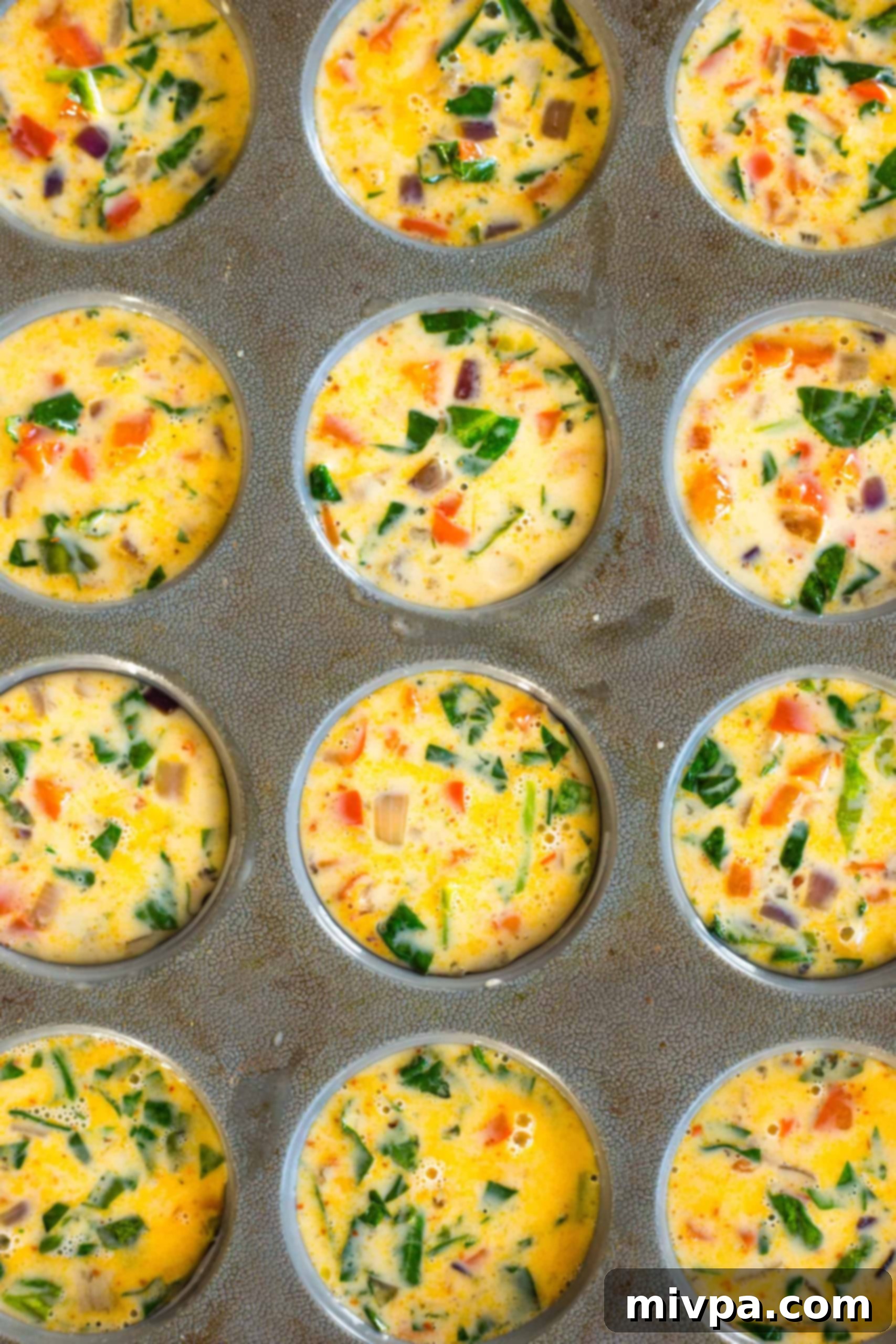 Mini Crustless Quiche Cups (Gluten-Free, Dairy-Free) Uncooked quiche batter in silicon muffin mold.