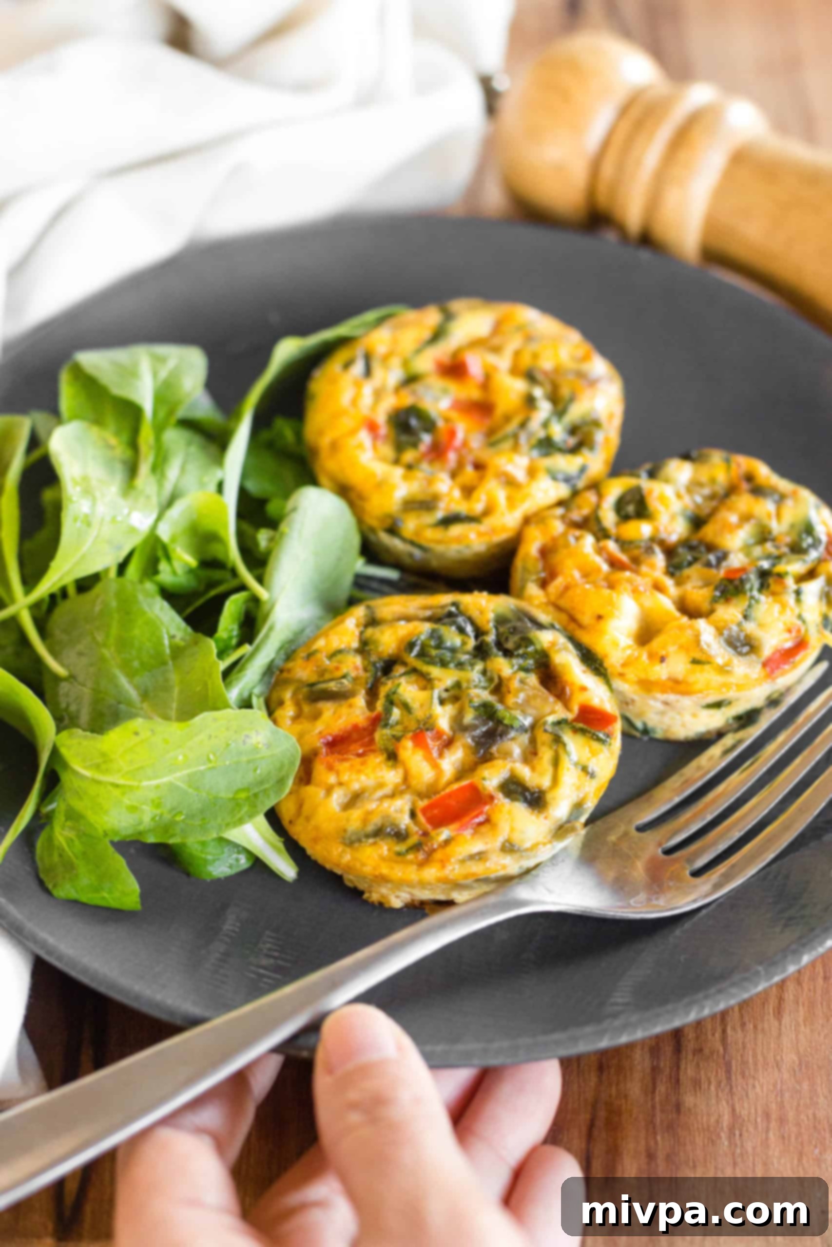 Mini Crustless Quiches (Gluten-Free, Dairy-Free) Holding a plate with crustless quiche cups and salad.