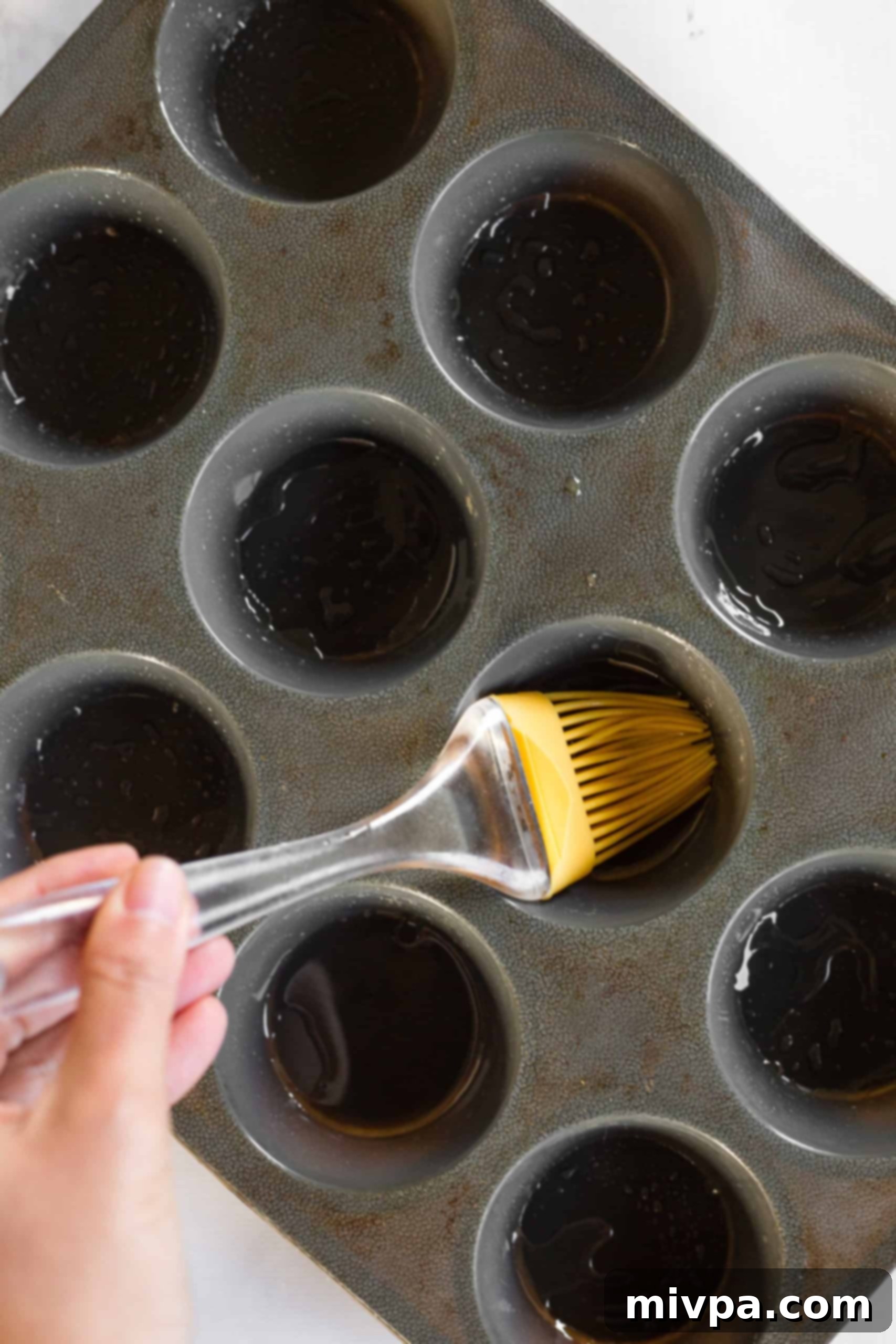 Mini Crustless Quiches (Gluten-Free, Dairy-Free) Using silicon brush to grease silicon mold.