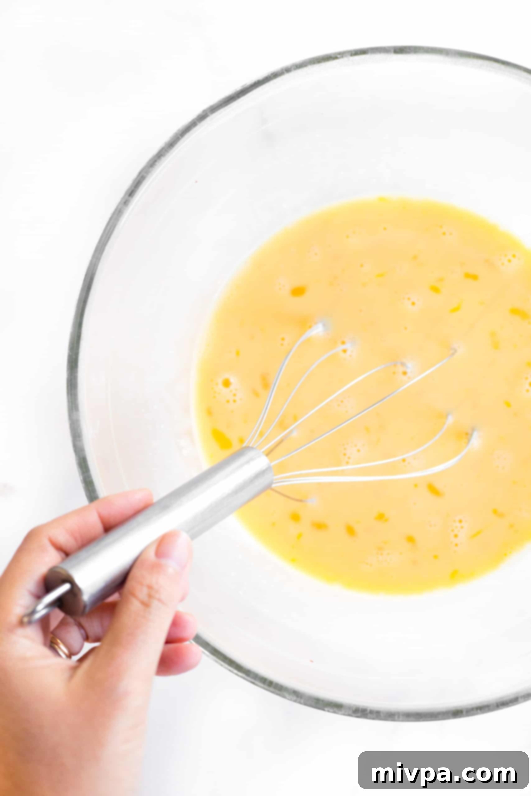 Mini Crustless Dairy-Free Quiche Muffins Whisking quiche batter in large mixing bowl.