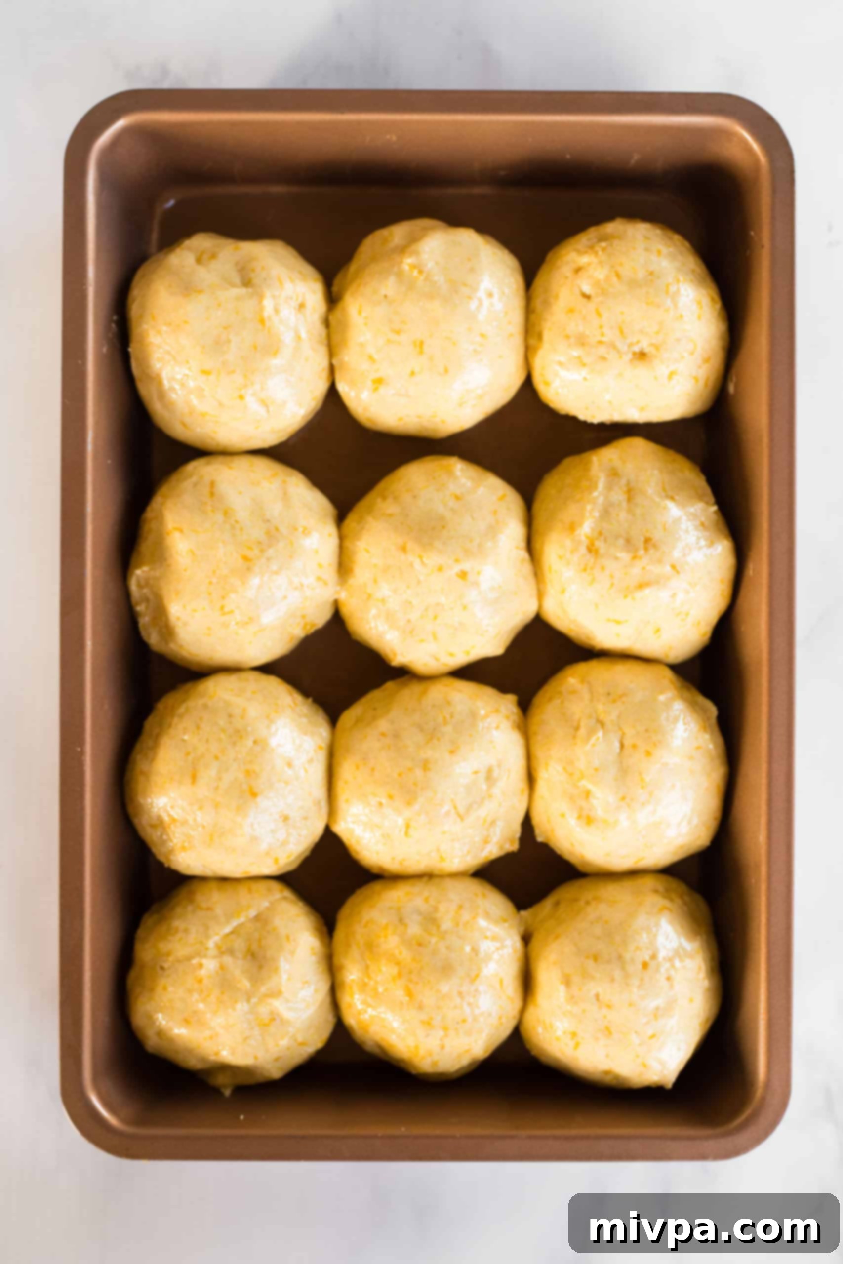 Balls of pumpkin bread dough in baking sheet.