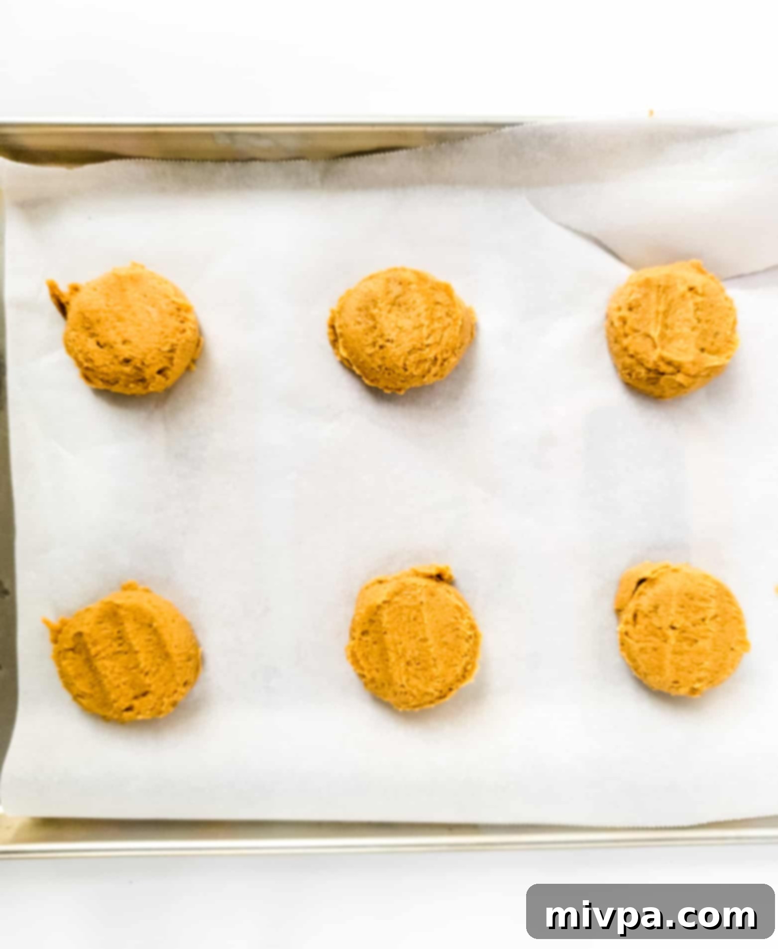 Gluten-Free Crumbl Cookie Recipe (Dairy-Free) Copycat crumbl cookie dough balls on parchment-lined baking sheet.