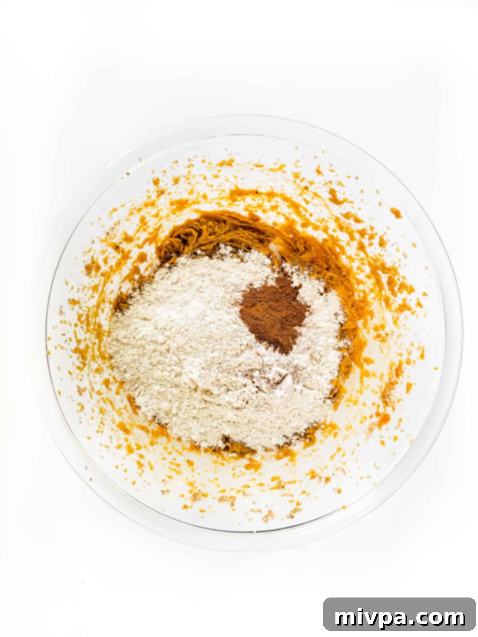Gluten-Free Pumpkin Crumbl Cookies (Dairy-Free) Flour and pumpkin pie spice over cookie dough in bowl.