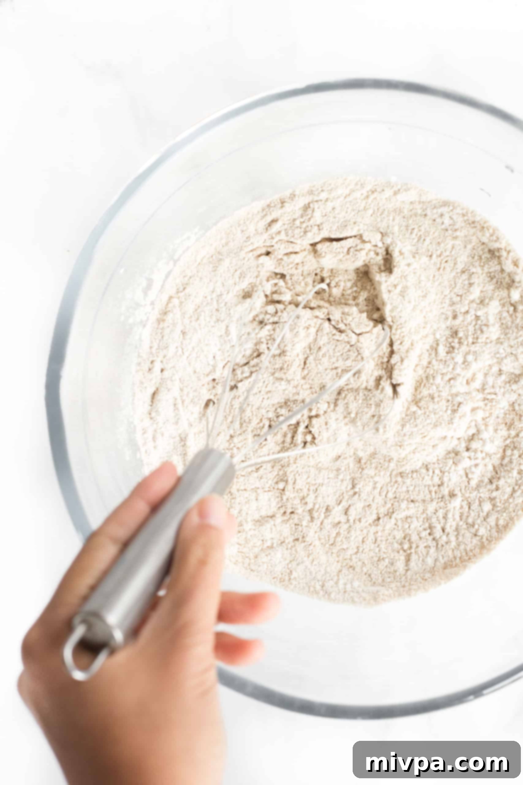 Gluten-Free Whole Grain Bread (Dairy-Free, Vegan) Whisking the gluten-free flour mixture in a large glass bowl for whole grain bread.