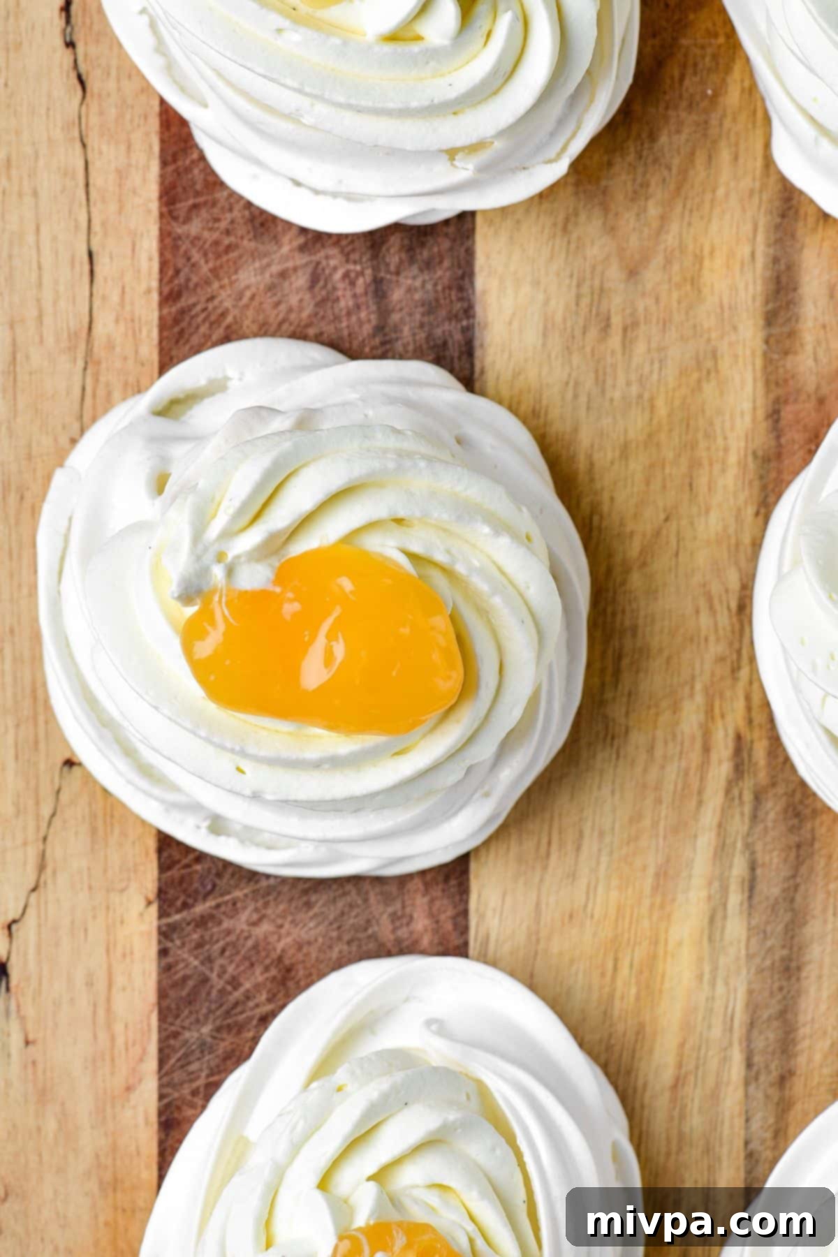 Lemon curd on to of mini pavlova nests